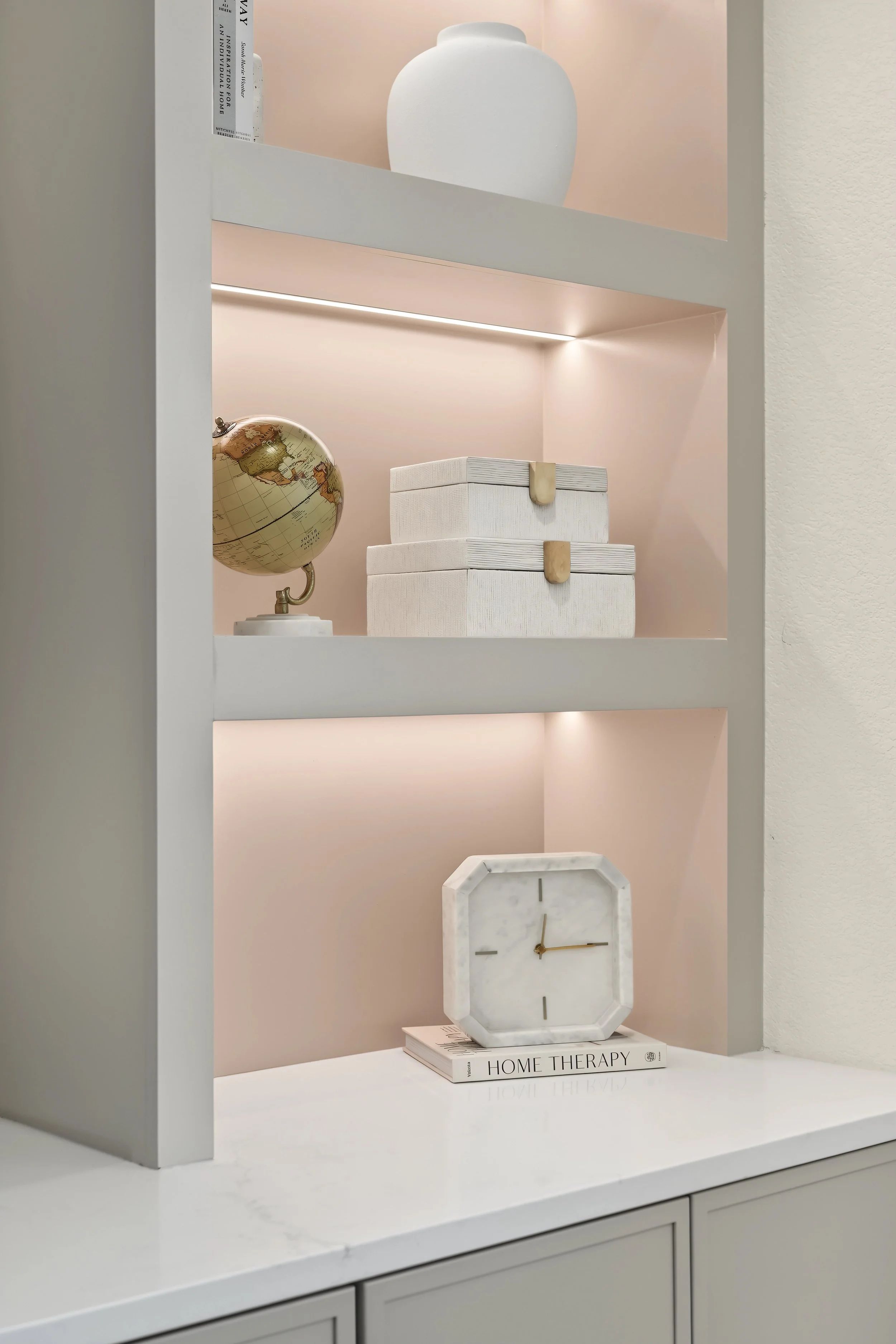 Custom built-in featuring integrated shelving, quartz countertops, warm accent lighting, and a Sherwin-Williams Accessible Beige finish for a seamless, refined look.