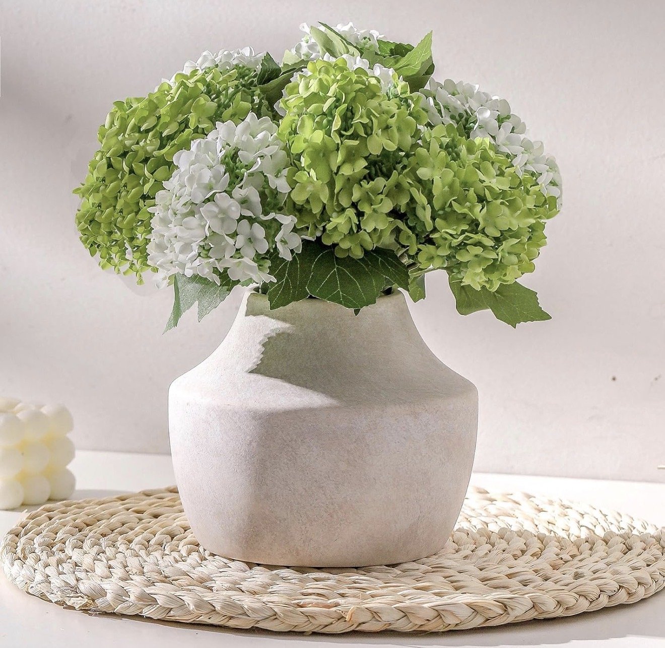 White ceramic vase with green hydrangea arrangement home decor