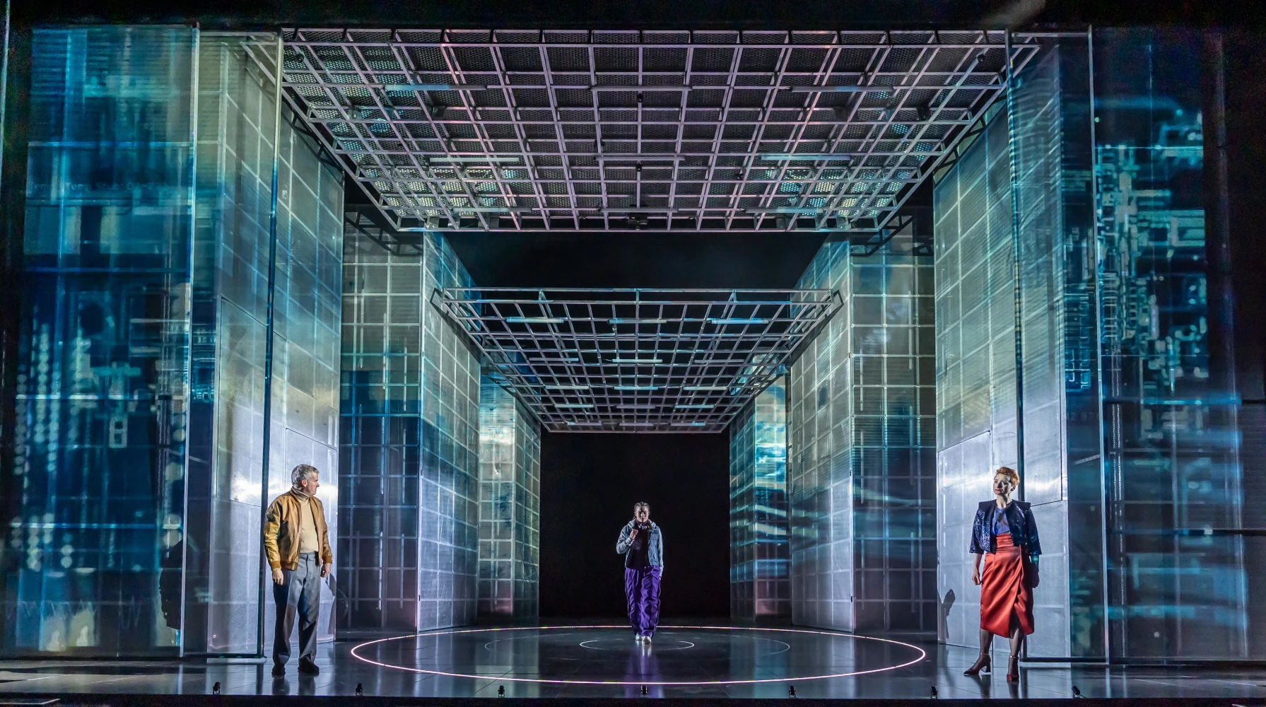 Three people standing on a stage with futuristic, holographic projections of technology and cityscape around them