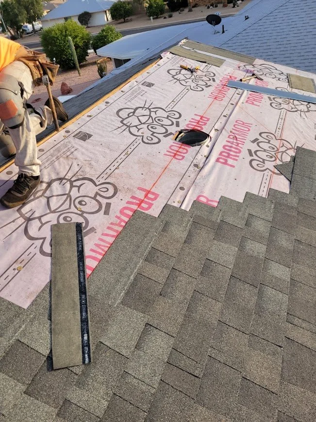 Asphalt shingle installation over synthetic underlayment on a residential roof.