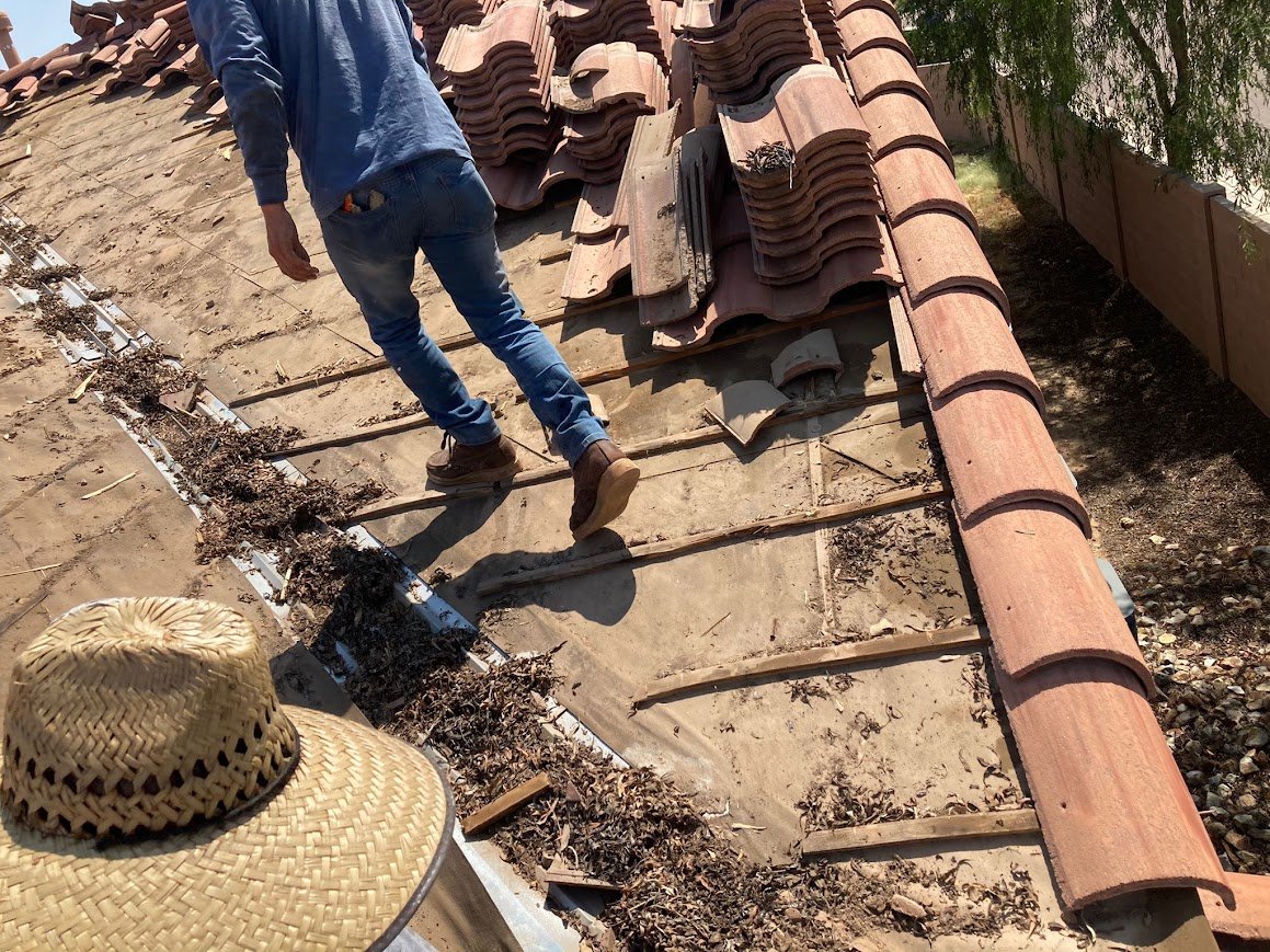 Concrete roof tiles removed and stacked during tile underlayment replacement.