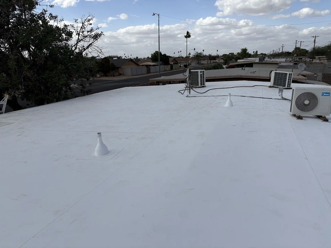 Completed white TPO roofing system with sealed penetrations and rooftop HVAC equipment.