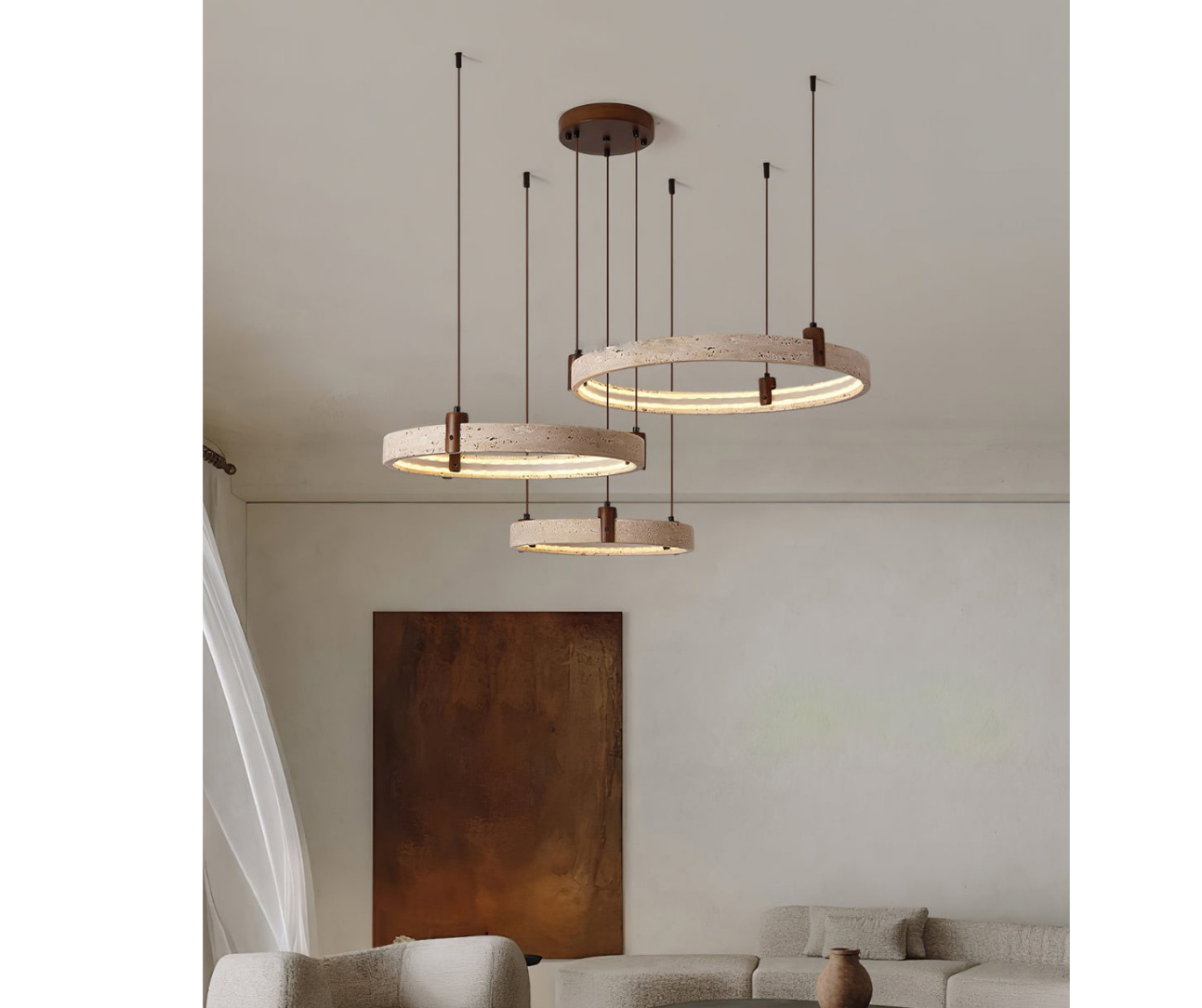 Modern circular chandelier with wood accents hanging from the ceiling over a beige sofa and abstract artwork on the wall.