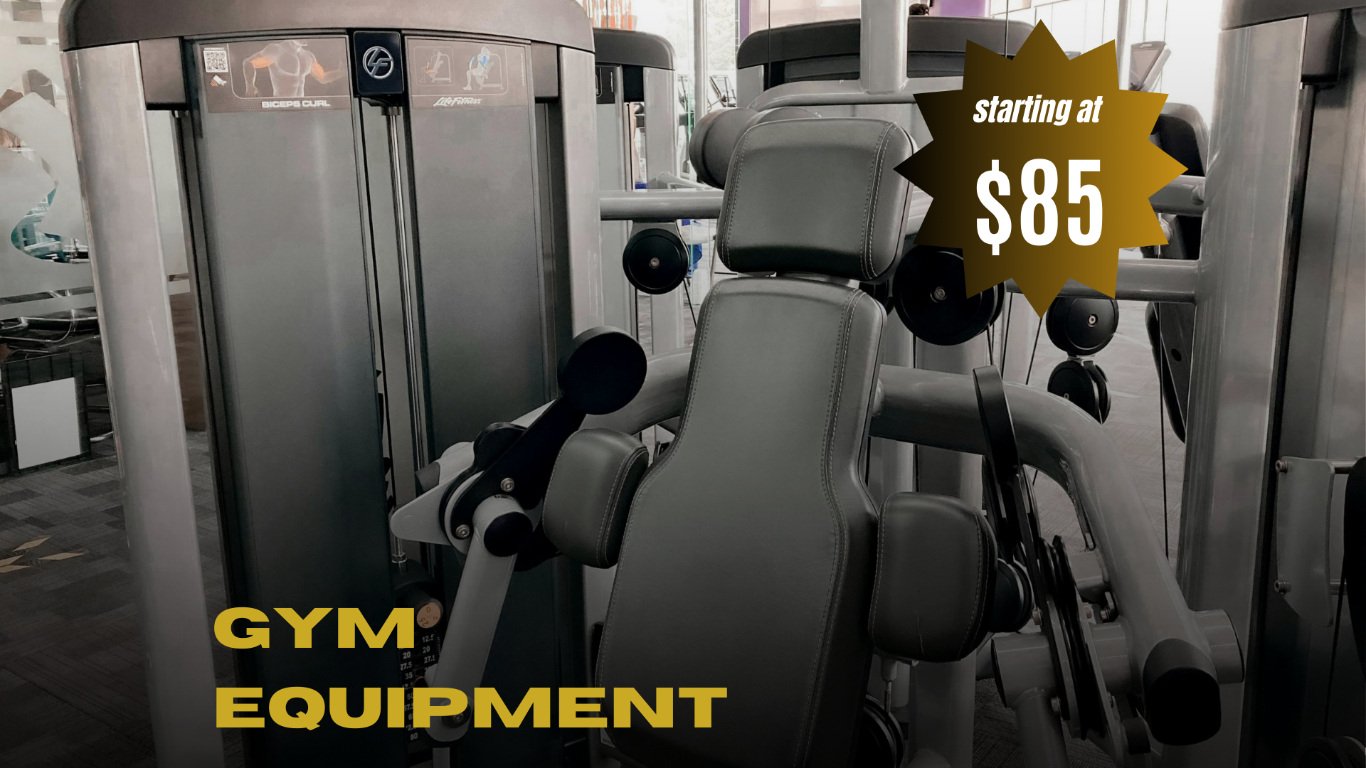 Gym equipment including a seat and weight machine at a fitness center with a sign indicating starting price of $85.