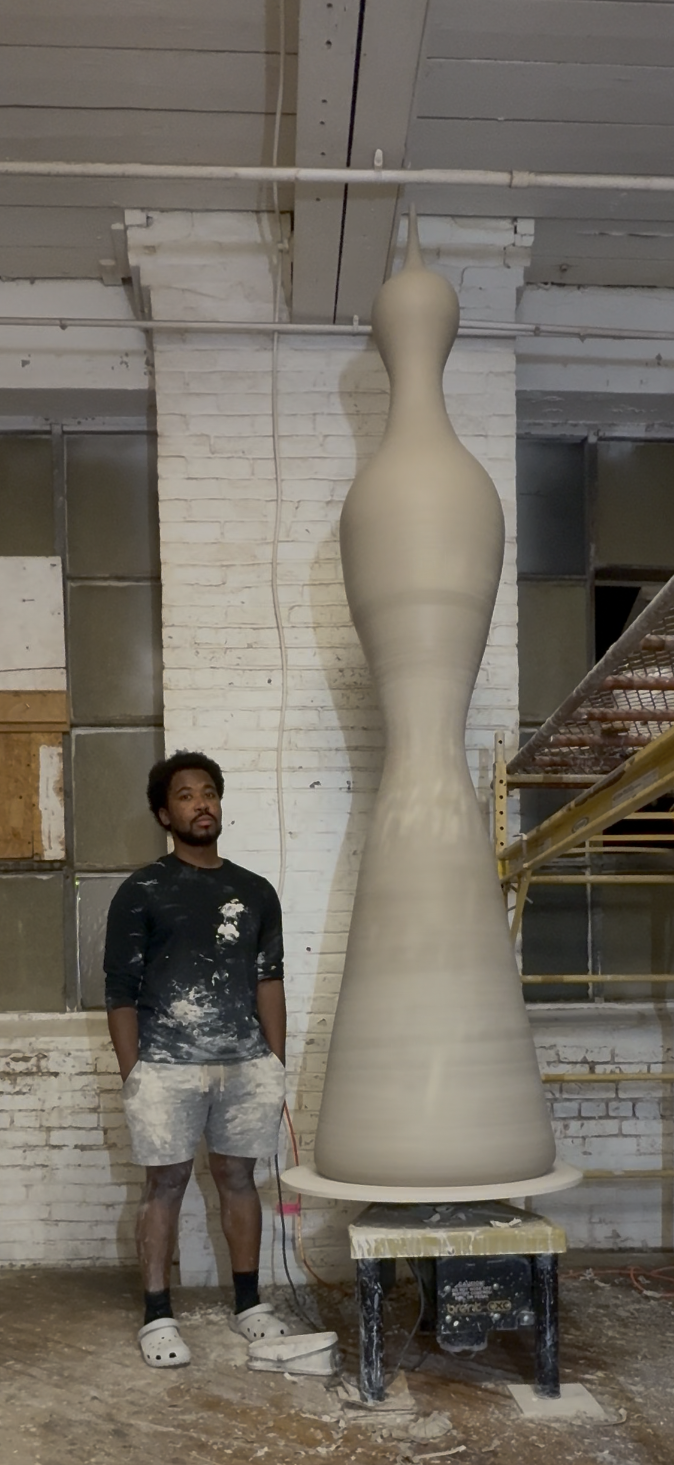 Khalil Jannah beside a tall wheel-thrown ceramic monolith in the studio (Wetlock Method, Chasing Giants)