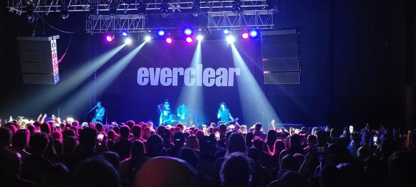 Concert with a crowd watching a band perform on stage at night, with lights and the word 'everclear' displayed on a screen behind them.