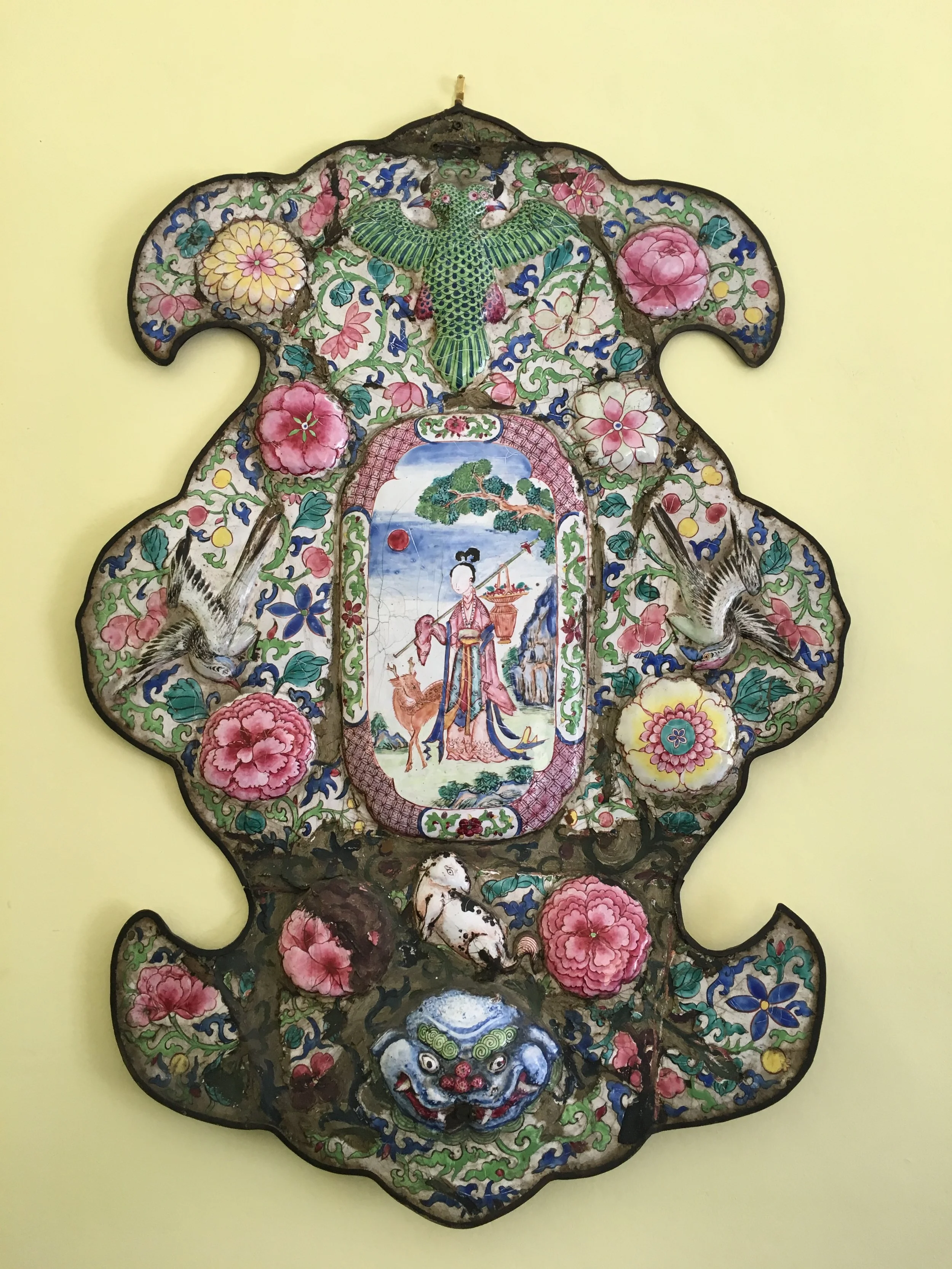 Decorative Asian-style wall hanging with floral patterns, birds, a central painted scene of a woman, and mythical creatures.