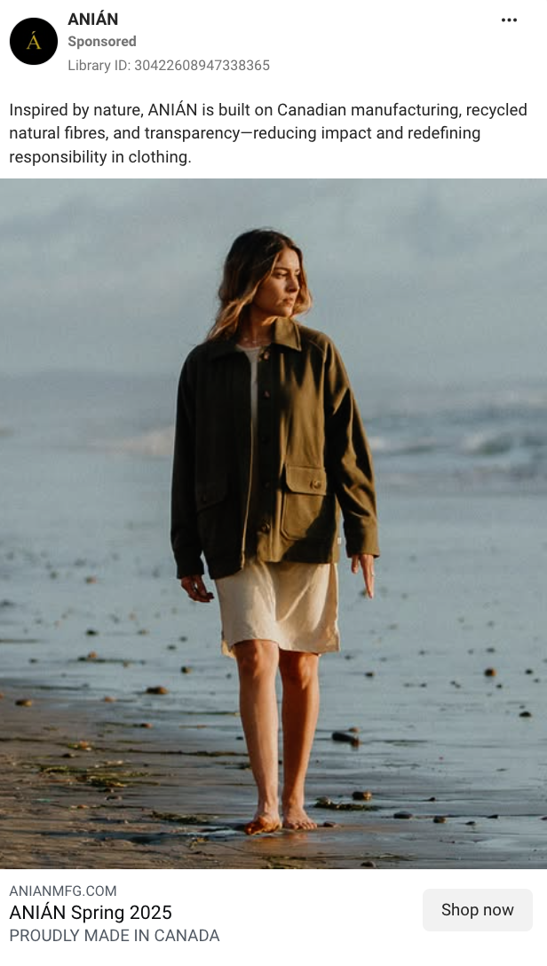 A woman walking barefoot on the beach, wearing a beige dress and a green jacket, with ocean waves in the background.