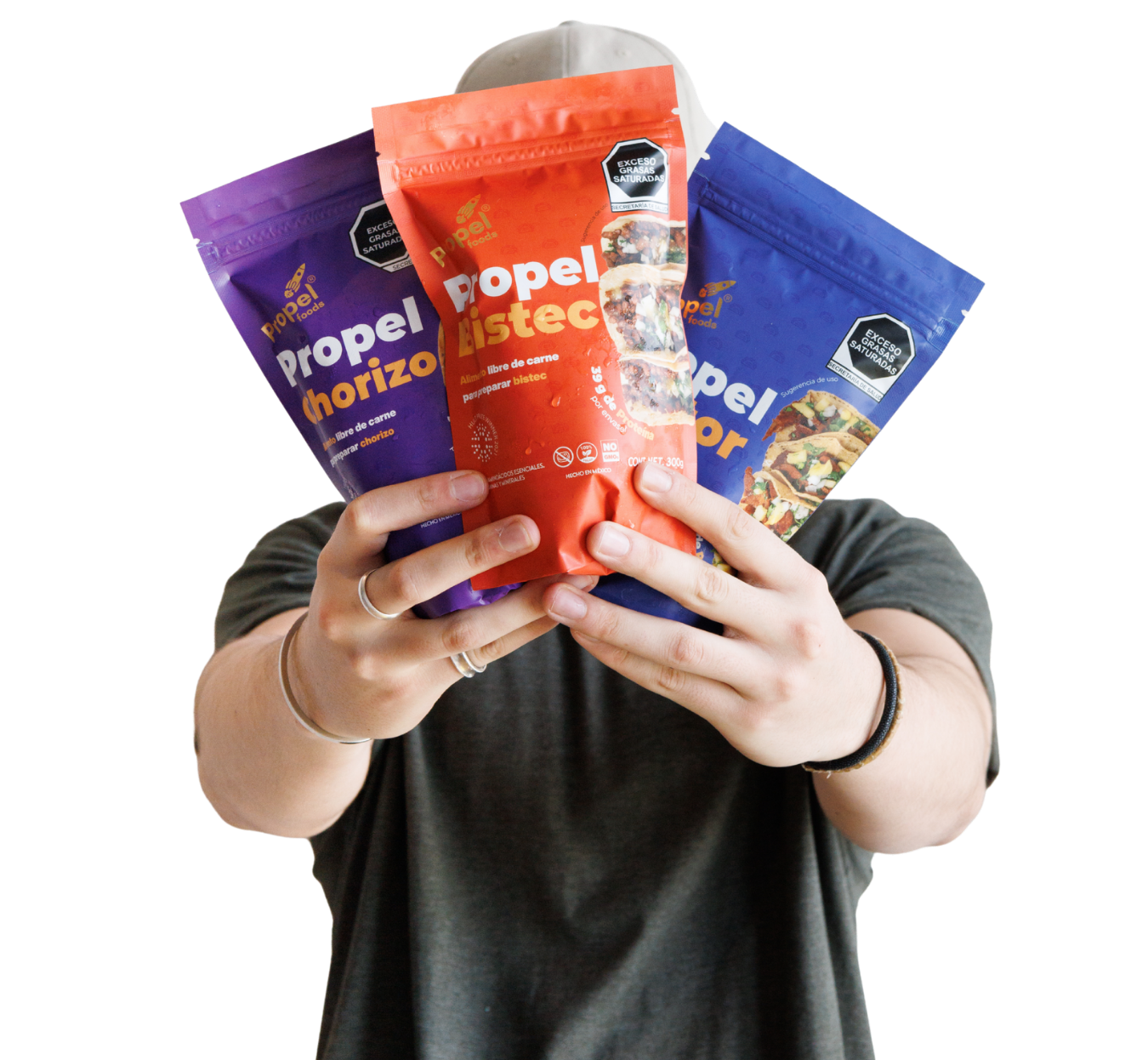 Persona sosteniendo tres bolsas de pouches Propel en diferentes colores, con imágenes de alimentos en las bolsas.