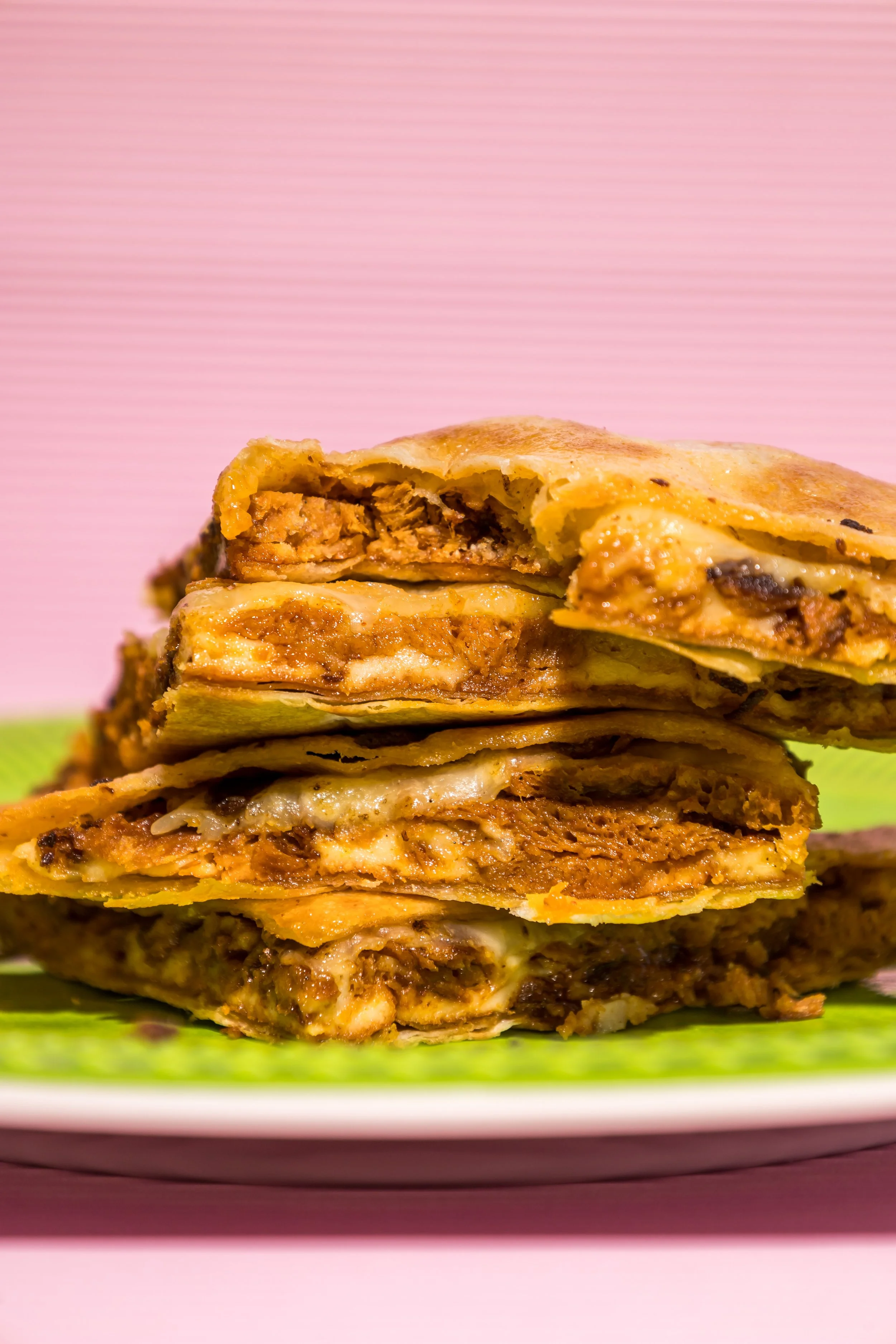 Tres porciones de tacos de pastor vegano con queso en un plato