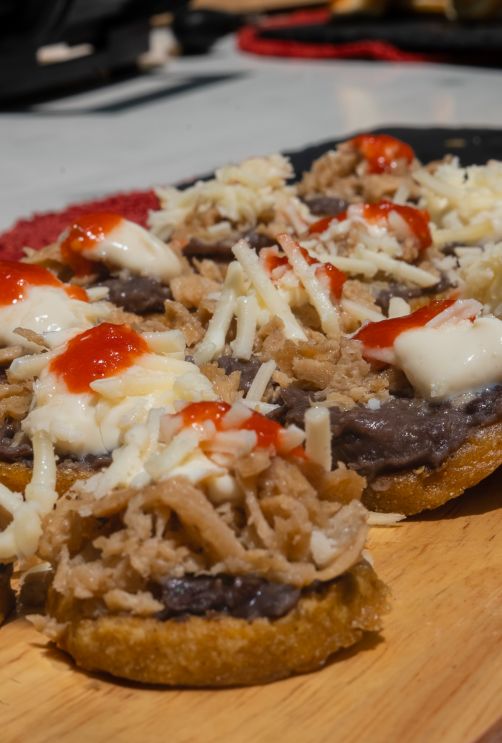 Pollo vegano deshebrado con queso rallado, y salsa en la parte superior, servidos sobre una tabla de madera.