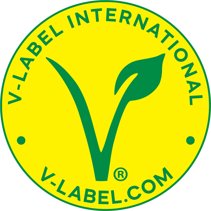 Logotipo circular de fondo amarillo con borde verde, con la palabra 'V-LABEL INTERNACIONAL' en la parte superior y 'V-LABEL.COM' en la parte inferior, ambas en letras verdes. En el centro, una letra 'V' grande en verde, con un brote de planta que emerge de la parte superior derecha.
