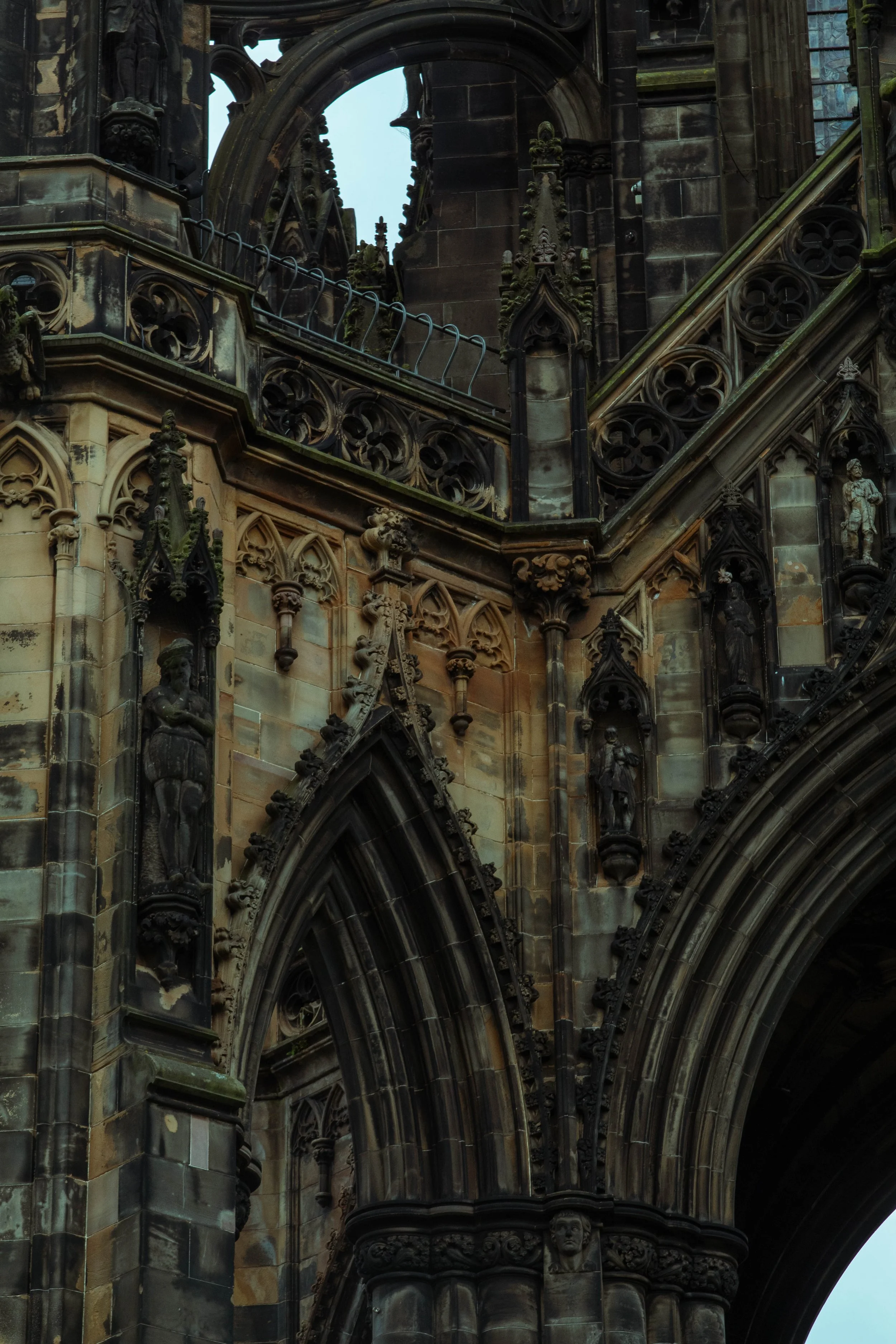 Close-up view of a Gothic cathedral's ornate stone architecture with detailed sculptures and pointed arches.