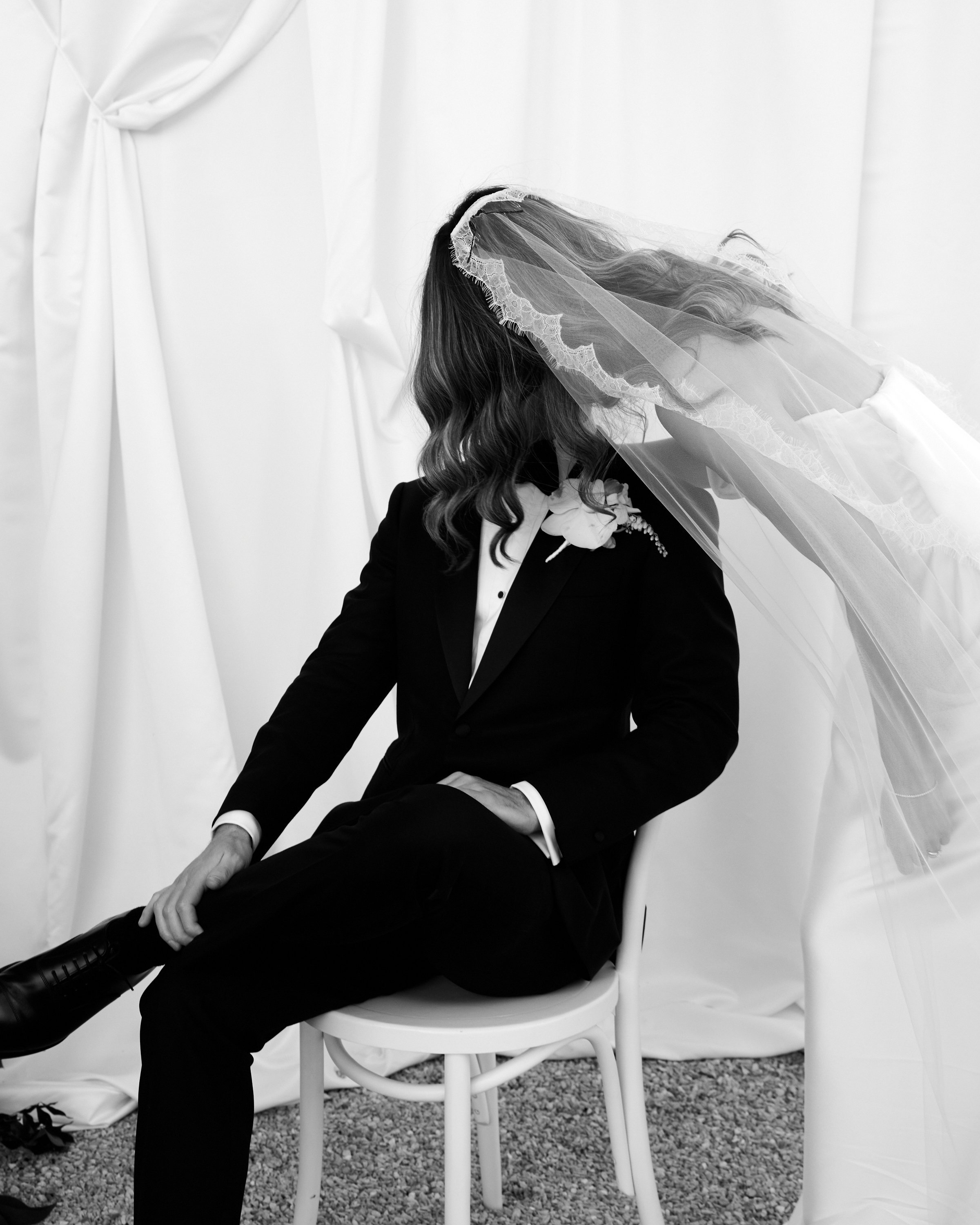 Black and White photo of Bride and Groom Kissing. Editorial style image photographed by a fashion photographer. 