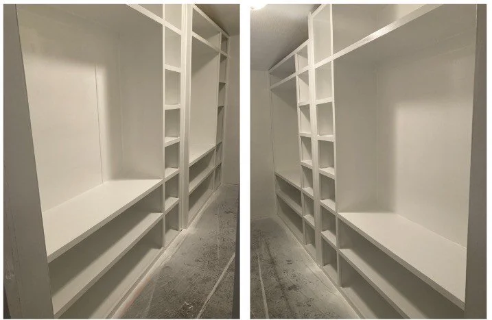 Empty white built-in storage shelves or pantry with multiple compartments in a corner of a room.