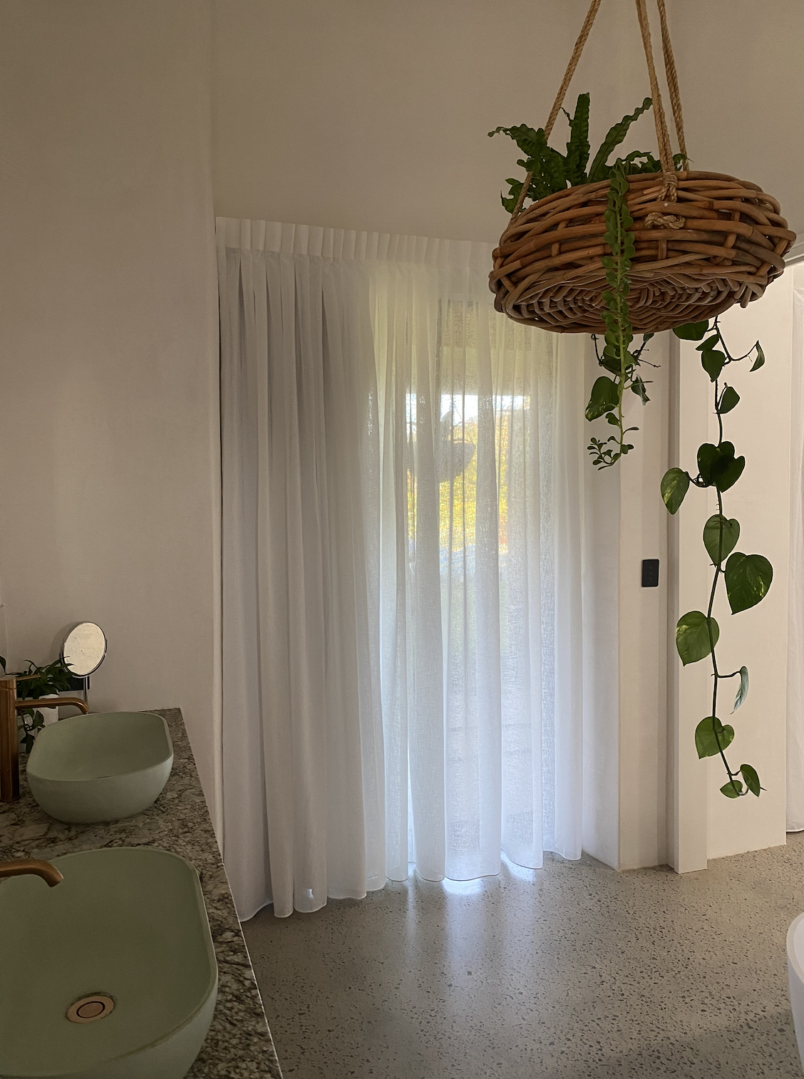 Bathroom with white sheer curtains.
