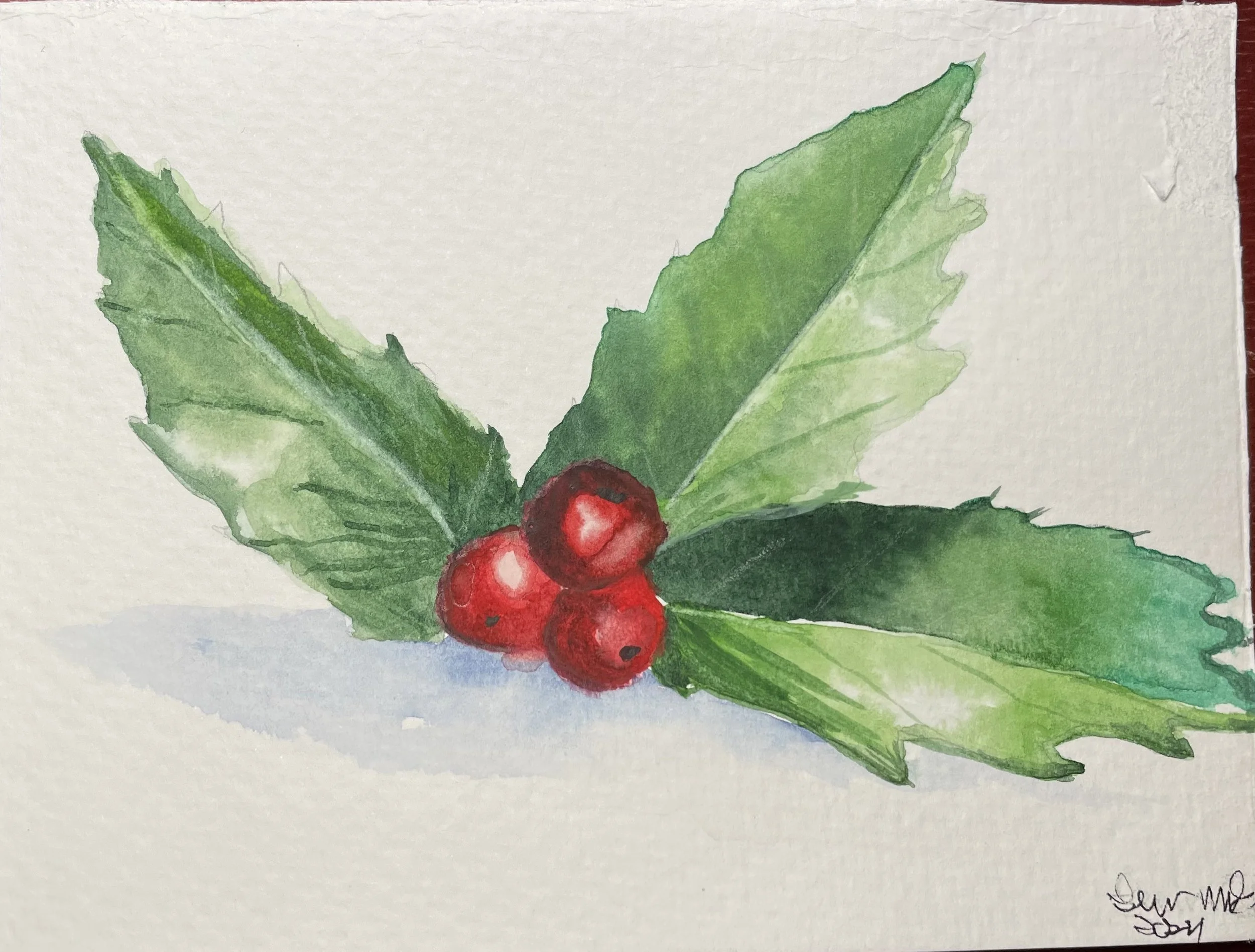 Watercolor painting of holly leaves with three red berries and a shadow underneath.