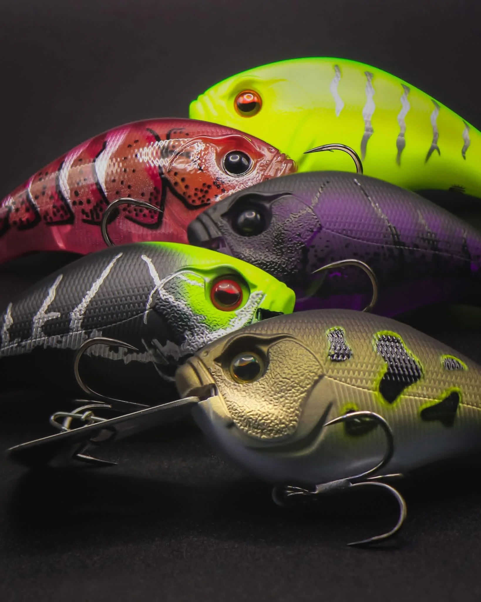 Collection of colorful fishing lures shaped like fish with hooks.