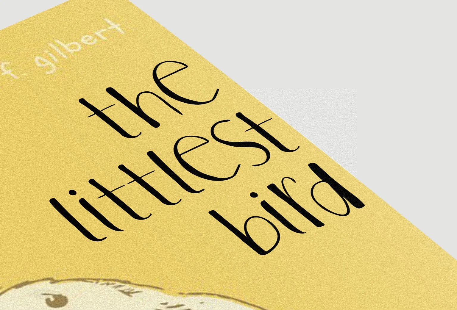 Close-up of a yellow pamphlet with the title 'the littlest bird' written in black cursive font.