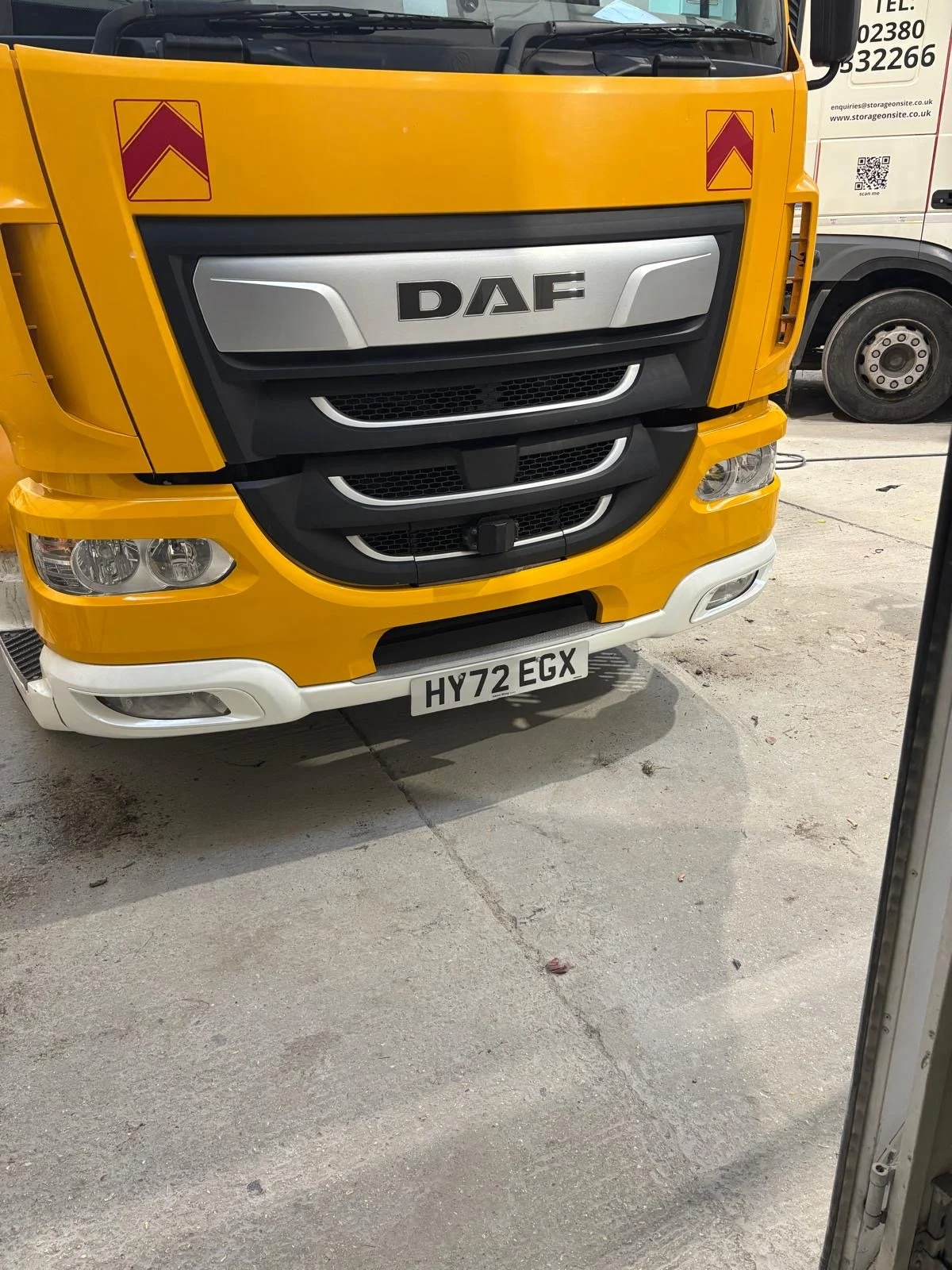 Front view of a yellow DAF truck with a silver grille and a UK license plate 