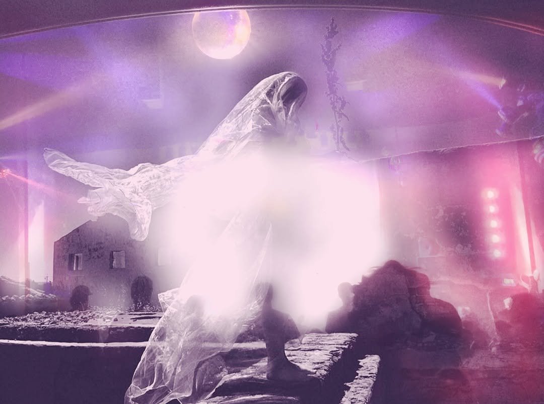 People looking at an illuminated artistic installation or sculpture that resembles a large, abstract, glowing figure with flowing, semi-transparent fabric and vibrant pink, purple, and white lighting effects.