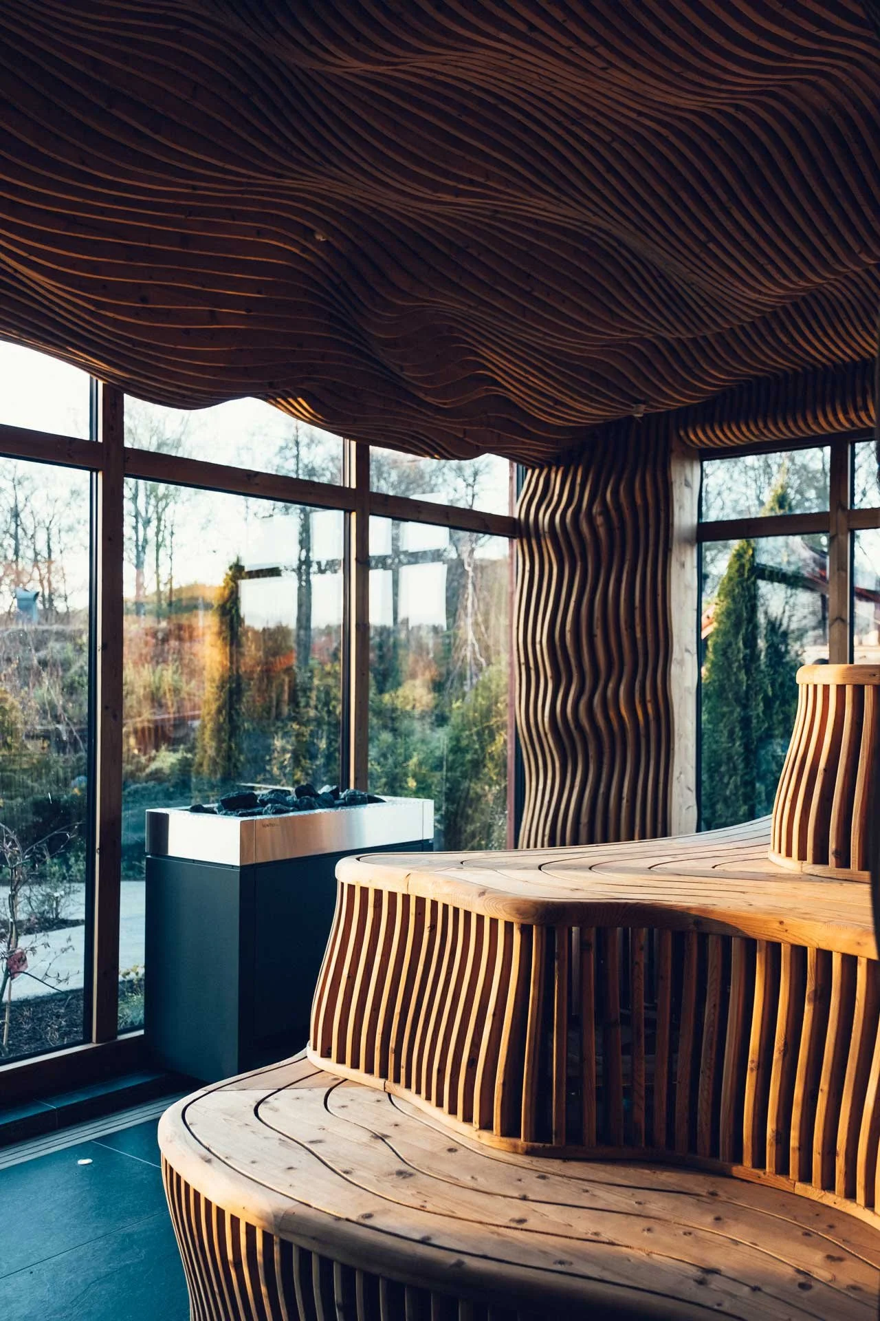 Ästad Vingård - Furubastu - stengolv - glasvägg som vätter ut mot grönska .jpg