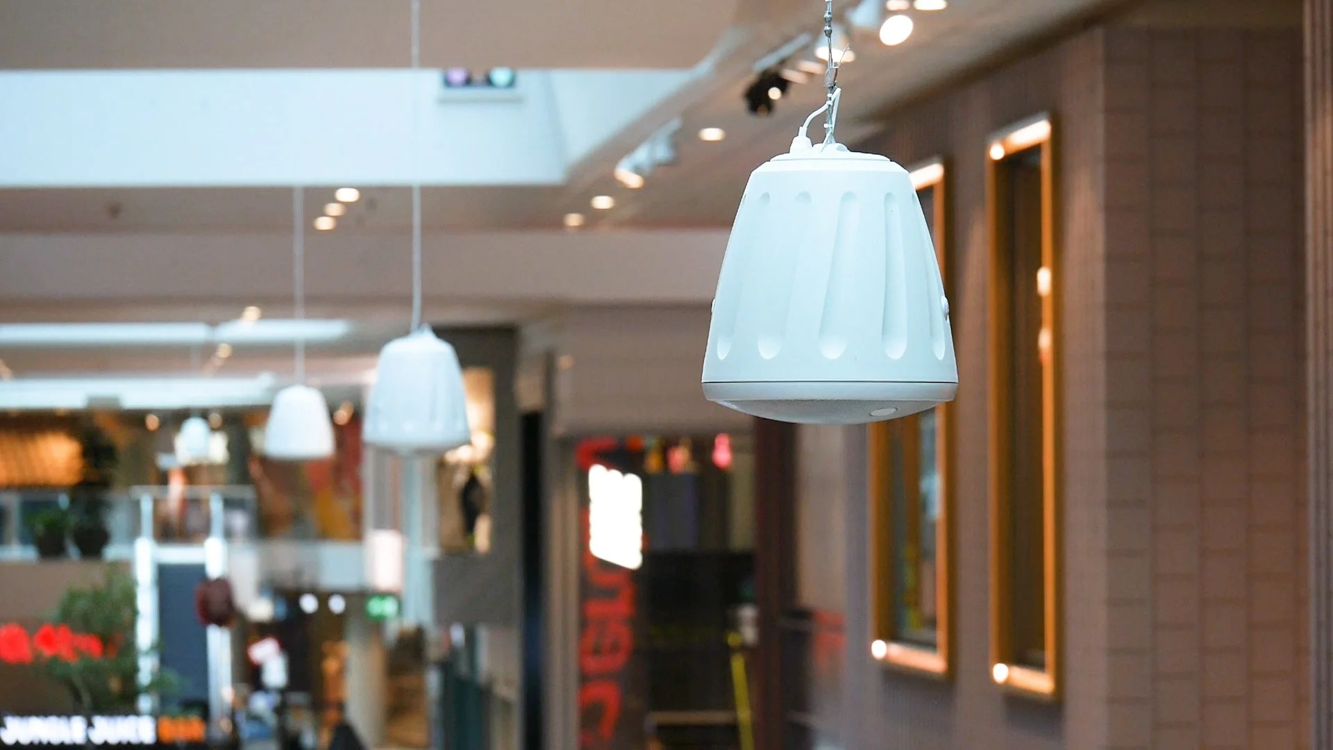 Gallerian - Bild på vita pendelhögtalare från taket.jpg