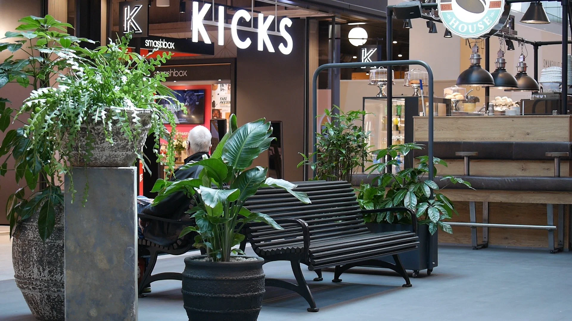 Gallerian - En bänk, grönska och skymtar kicksbutiken.jpg