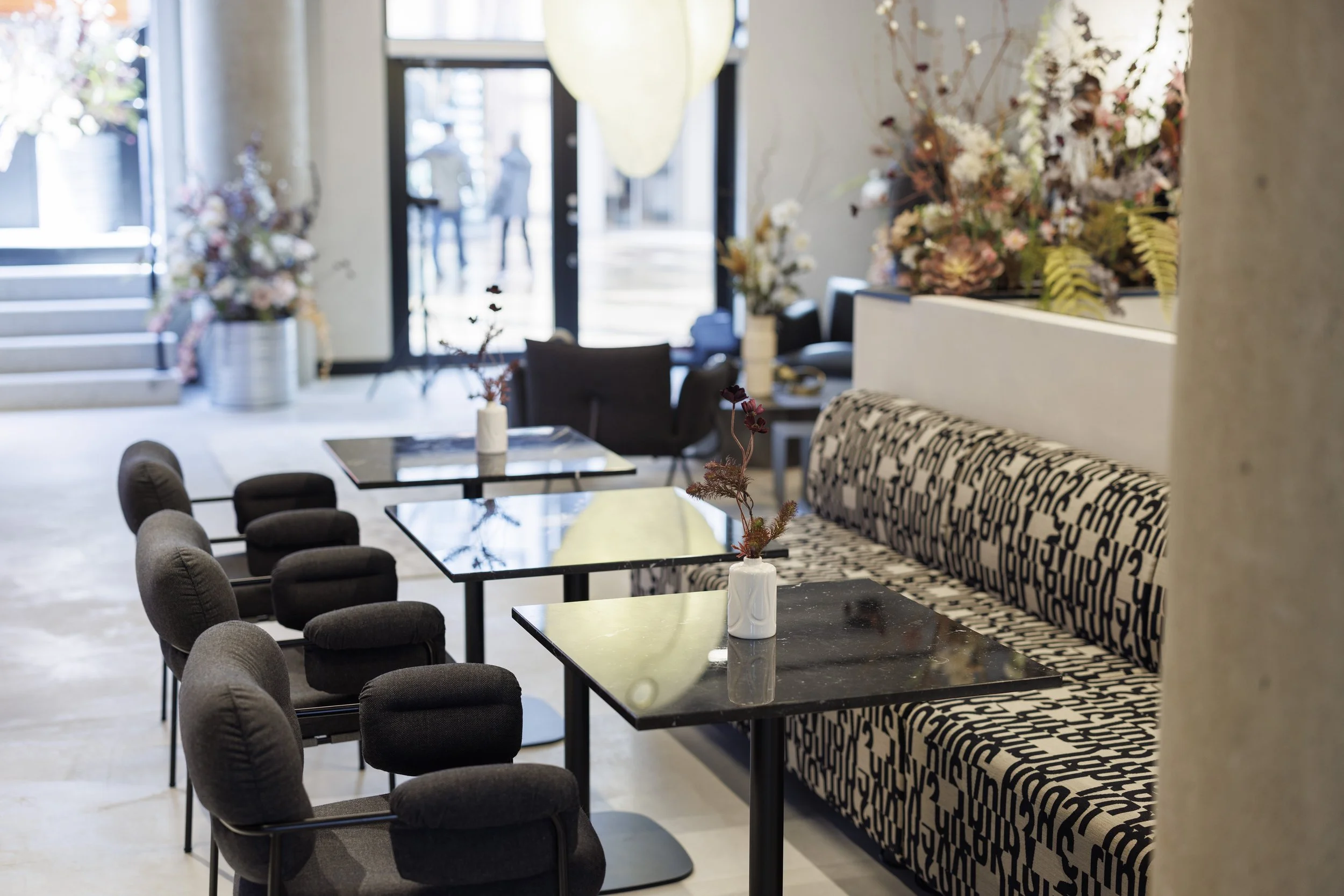 Arena Triangeln - Matbord - Svarta stolar - Svartvitsoffa - Rummet vätter ut mot gatan - Glasfönster.jpg