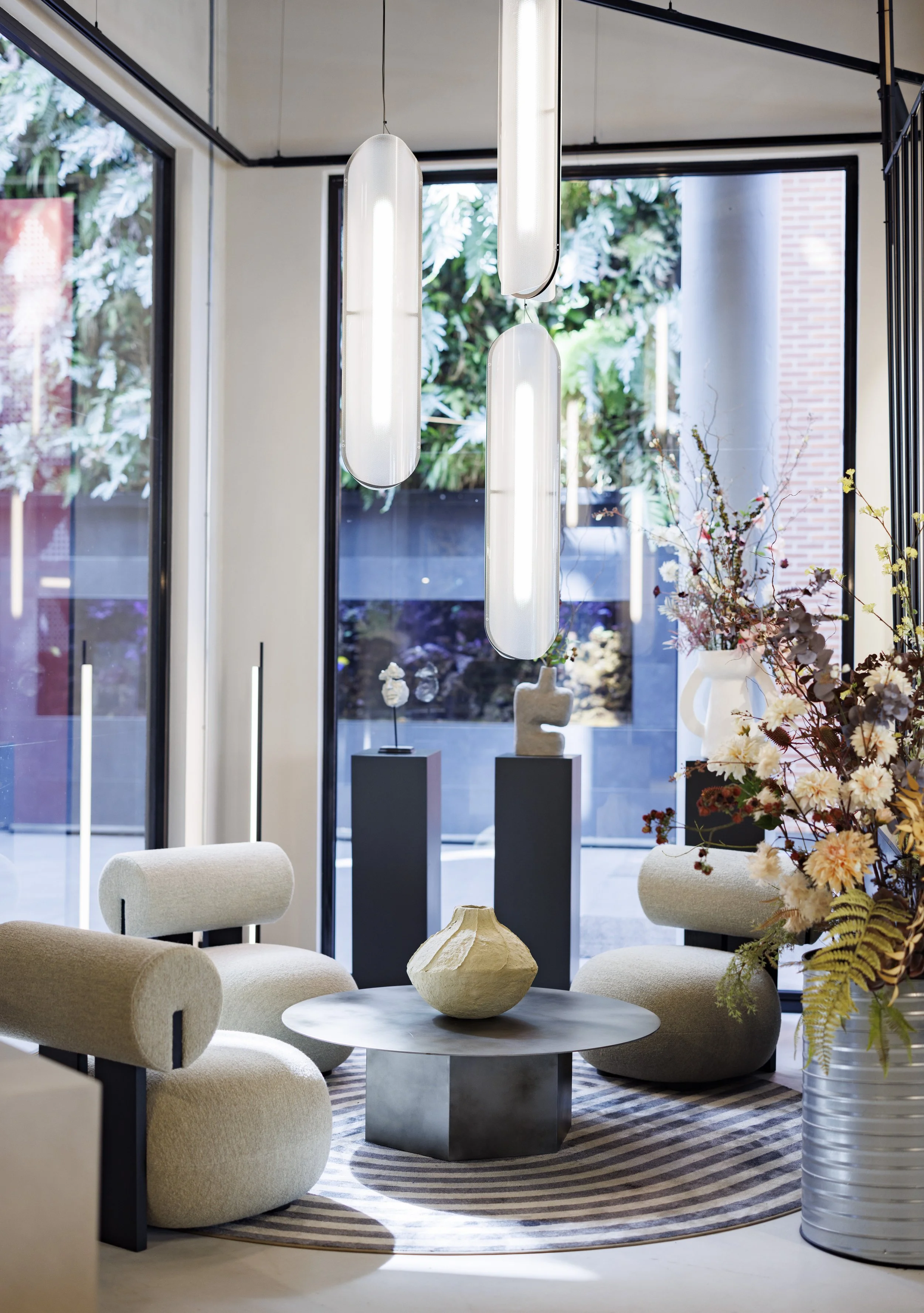 Arena Triangeln - Loungeyta med bulliga fotöljer - i ett hörn - glasväggar som vätter ut mot gata.jpg