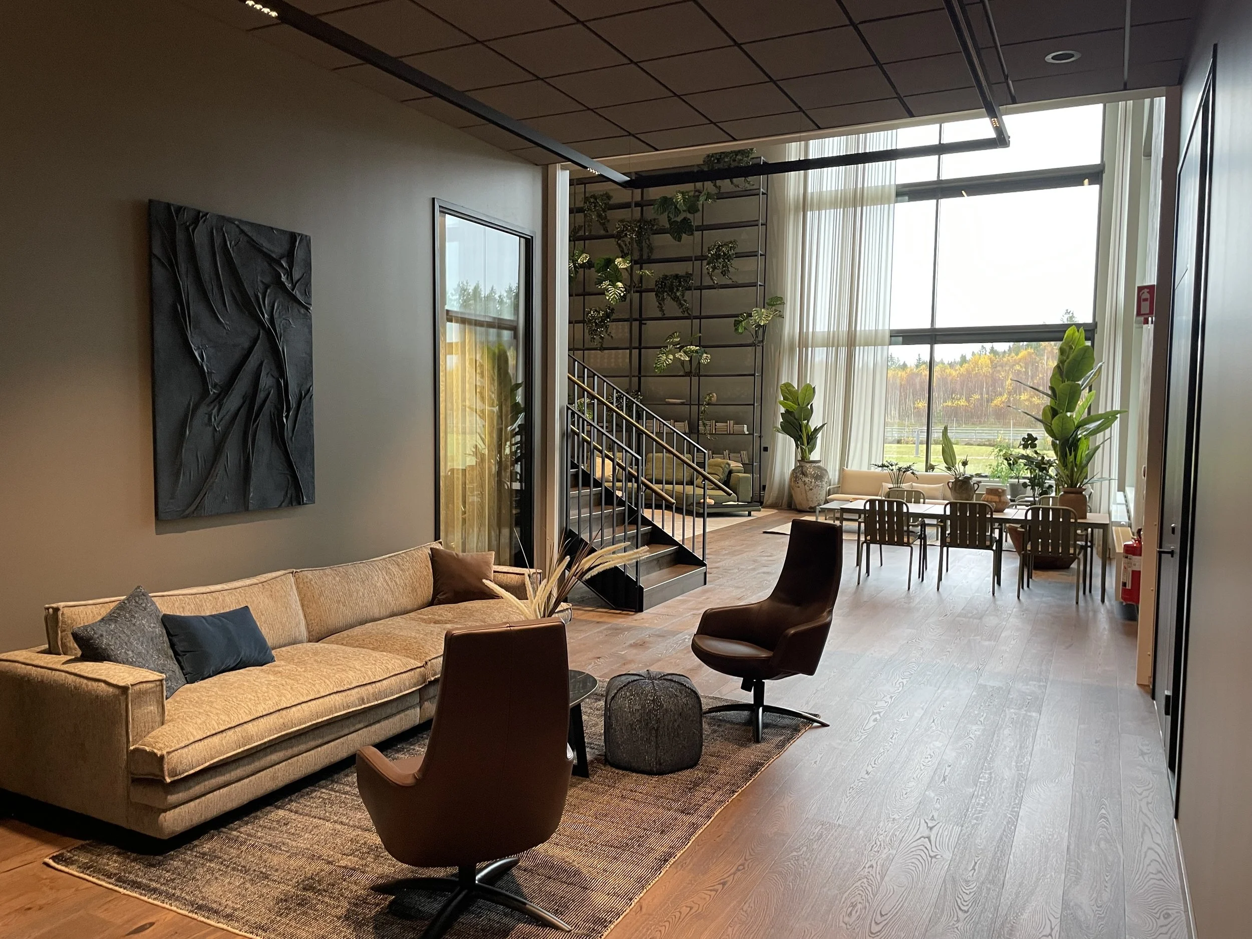 Stommen - Lounge yta - svart tavla på vägg - brun soffa - bord och stolar.jpeg