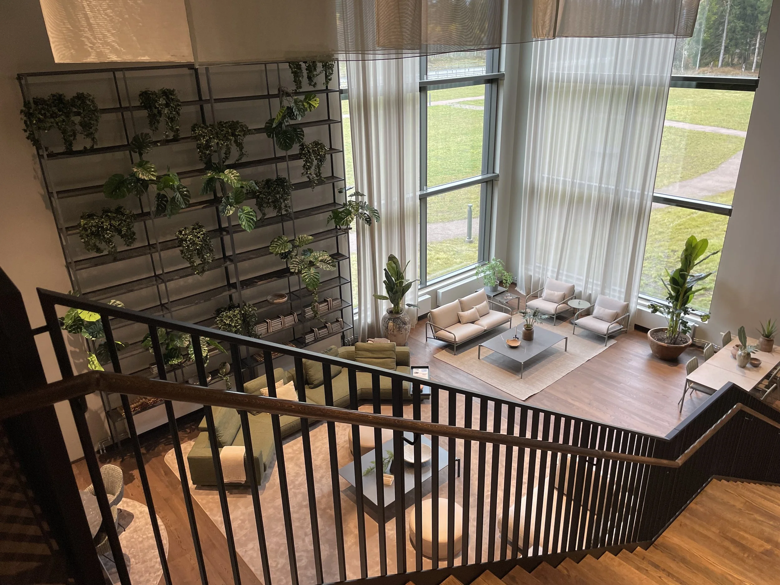 Stommen - Loungeyta - högt i tak - trappa - växtlighet på väggar - grön soffa - kuddar.jpeg