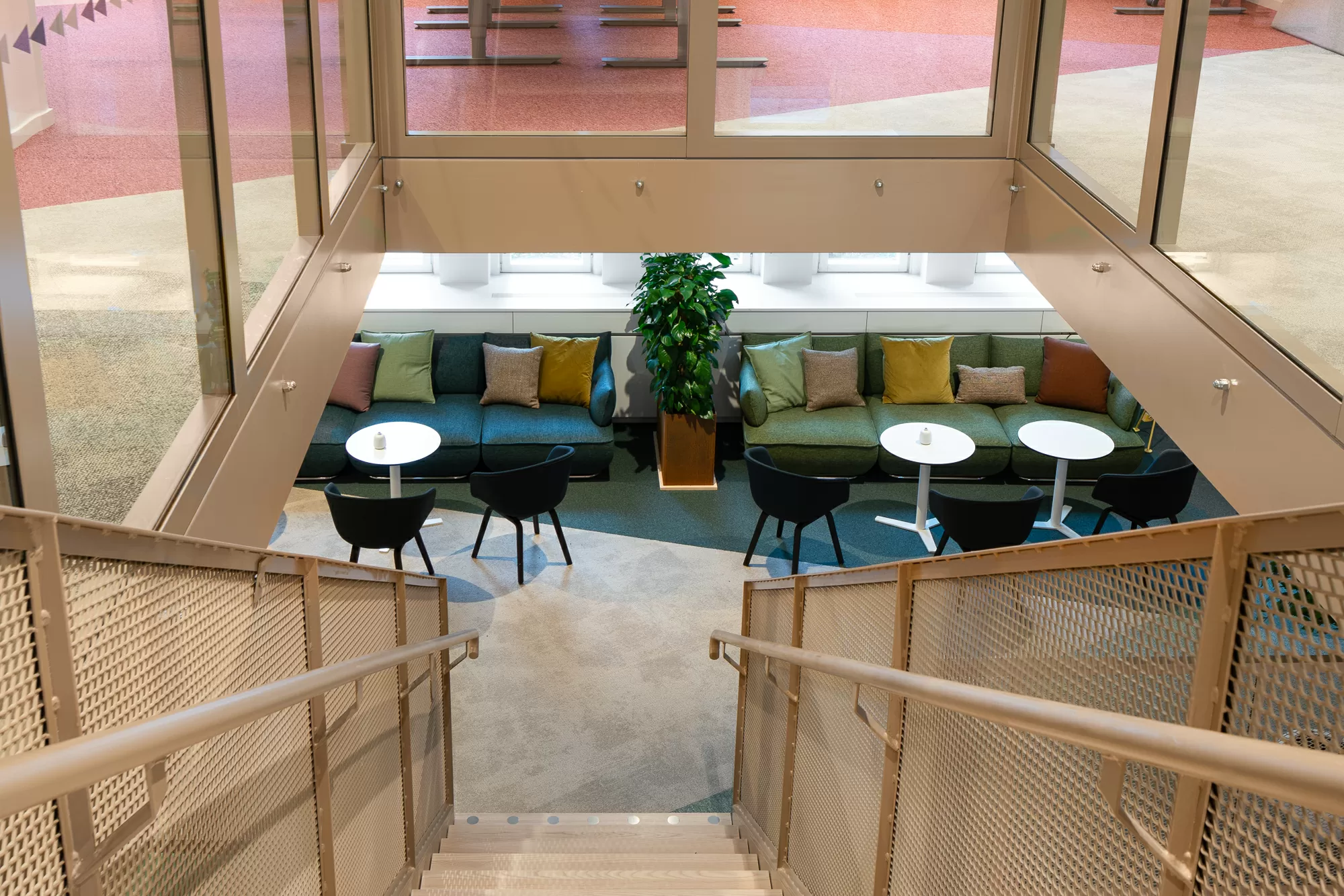 Vision - Trätrappa som vätter mot lounge yta - soffor och kuddar i olika färger.png