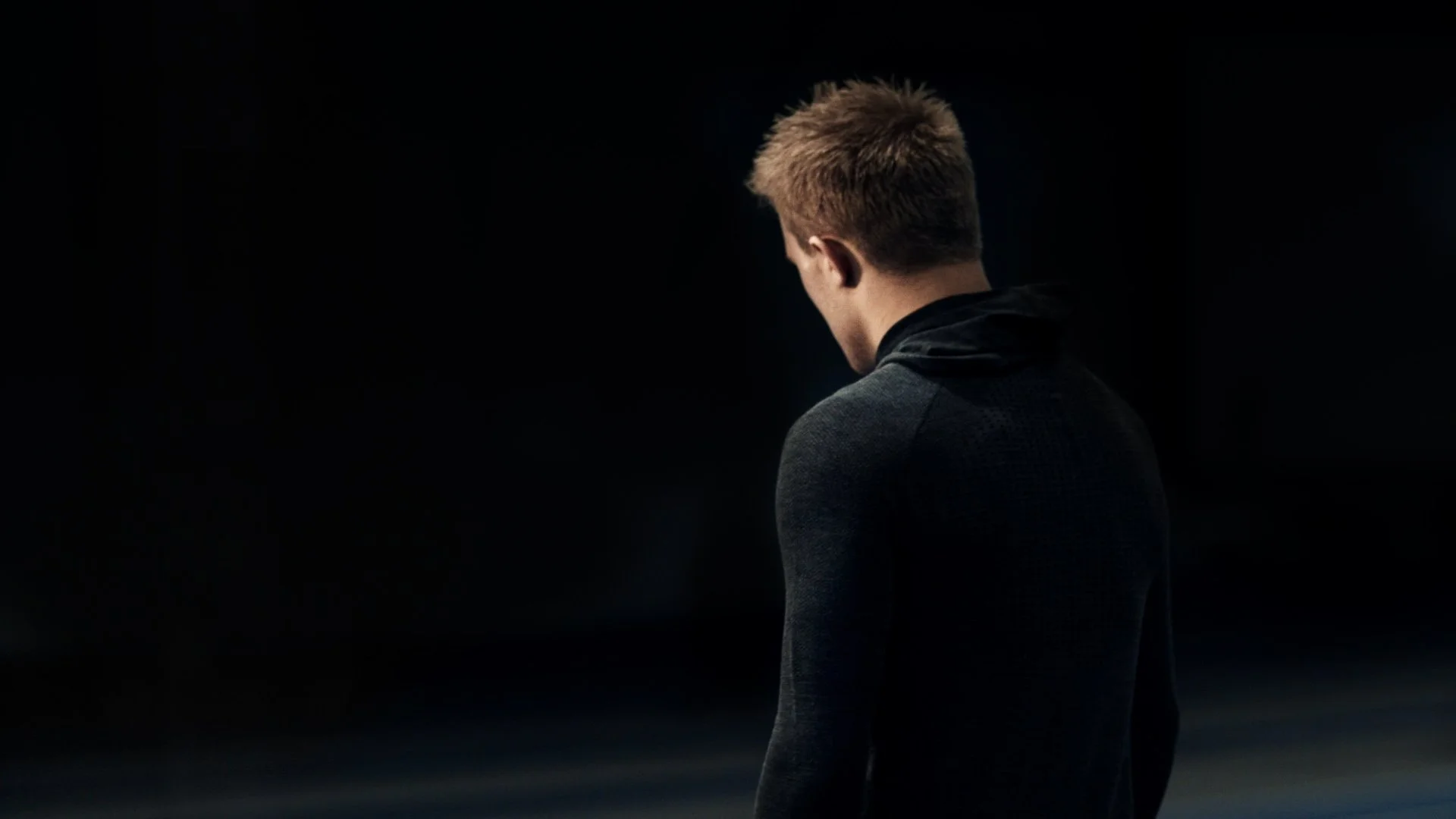 The Impossible Run - En man i ett mörkt rum - bild tagen bakifrån.jpg