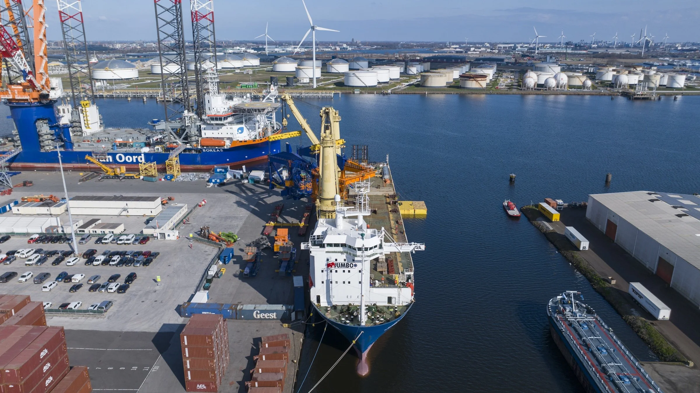 Port of Amsterdam heavy-lift operations Jumbo Maritime Jubilee vessel. Cargo offloading documentation coordinated around active crane operations terminal logistics Schiphol controlled airspace.