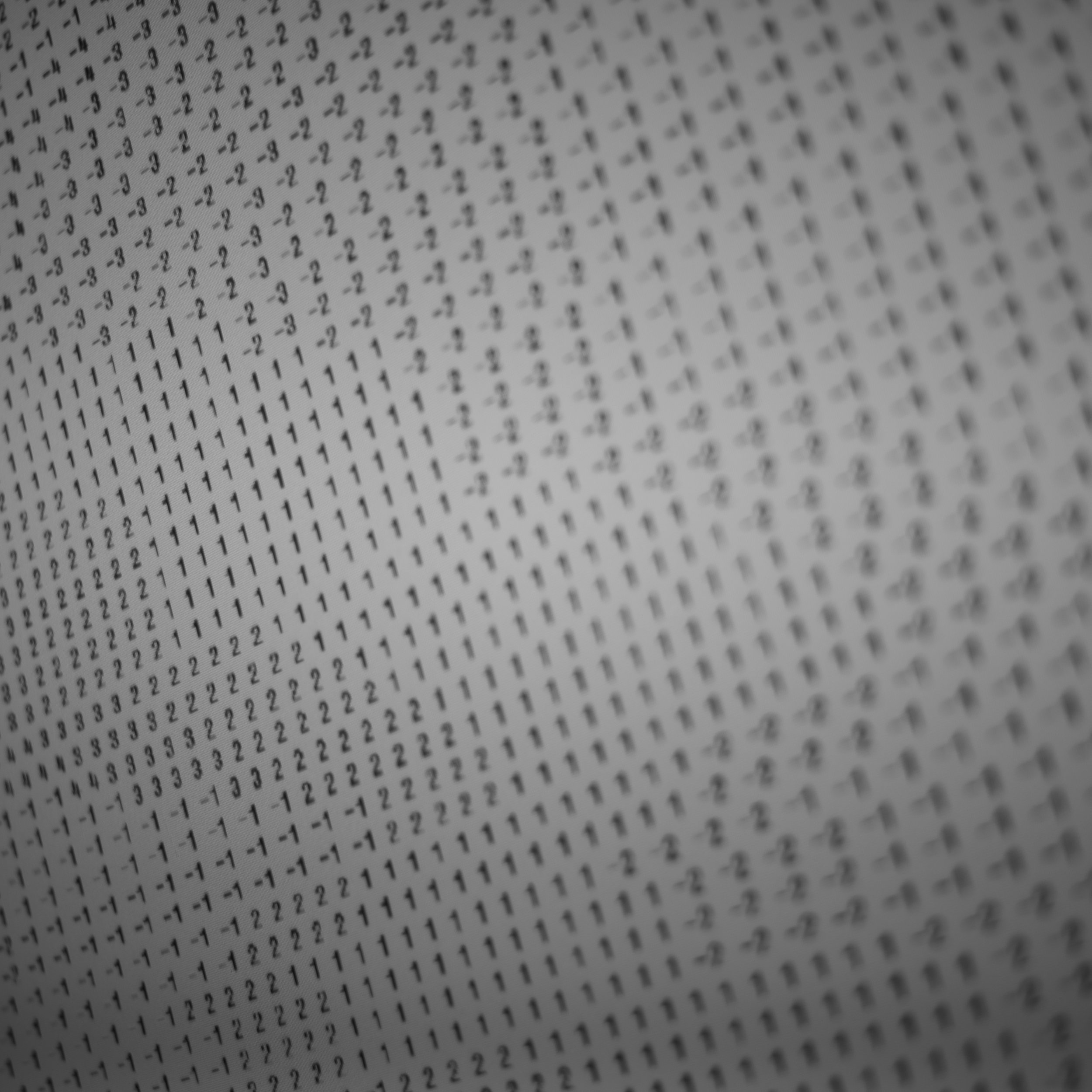 Close-up of a printed page with rows of numbers and symbols, including '1', '2', '3', '-1', '-2', '-3' arranged in a wave-like pattern.