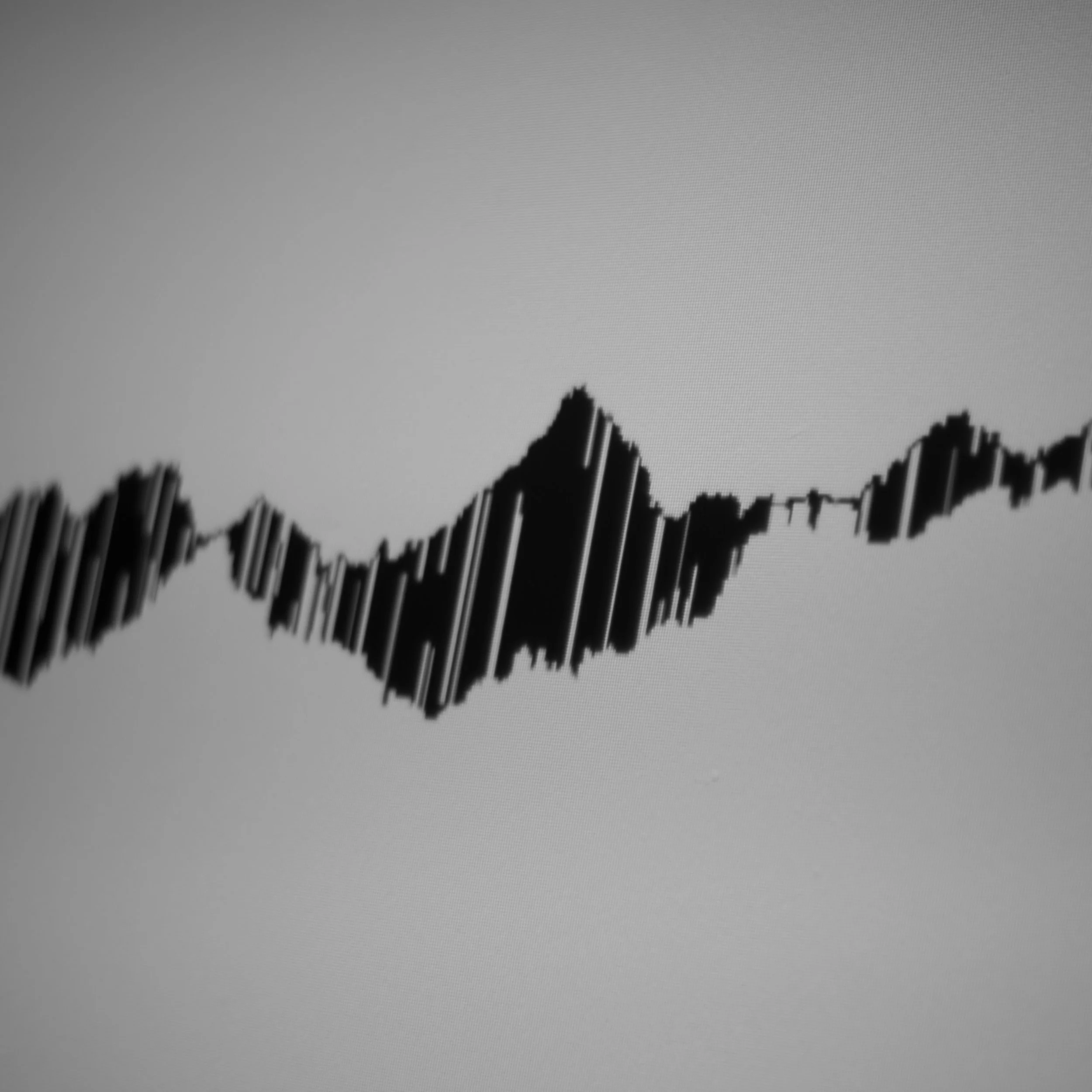 Black wave graph resembling volatile market on a light gray background