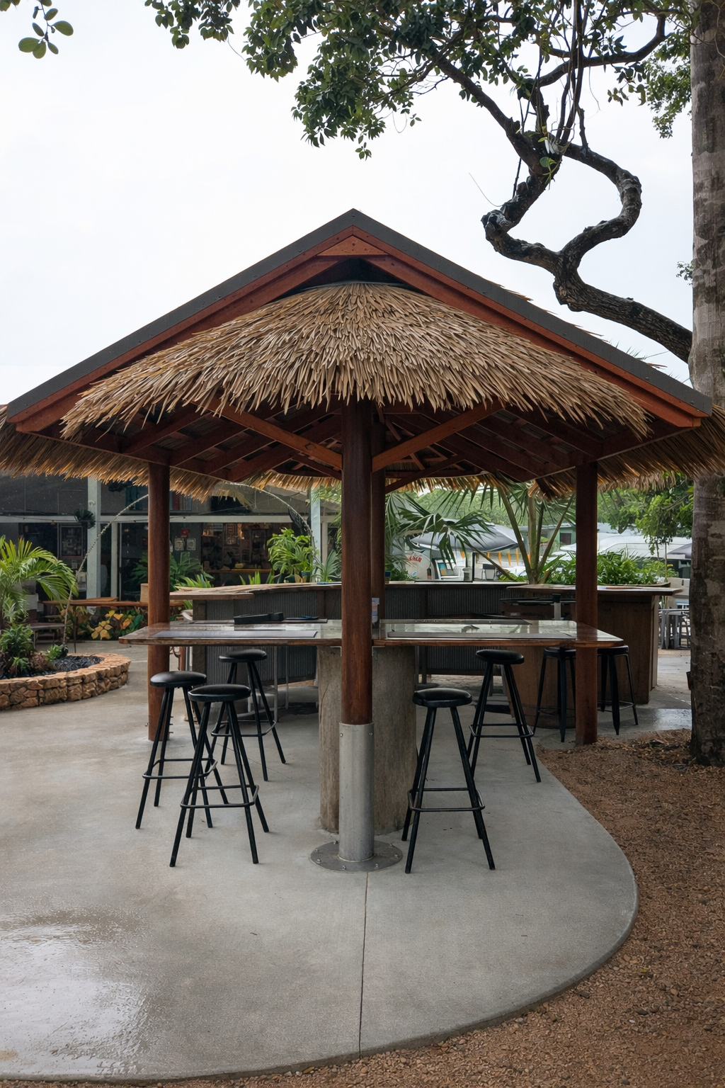 Four-post compass hut bar with thatched roof