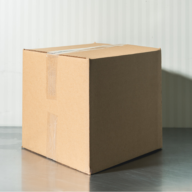 A cardboard box with packing tape, sitting on a gray floor against a light-colored, vertically striped wall.