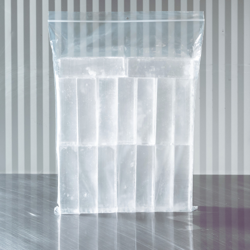 Clear plastic bag filled with ice cubes against a metal wall background.