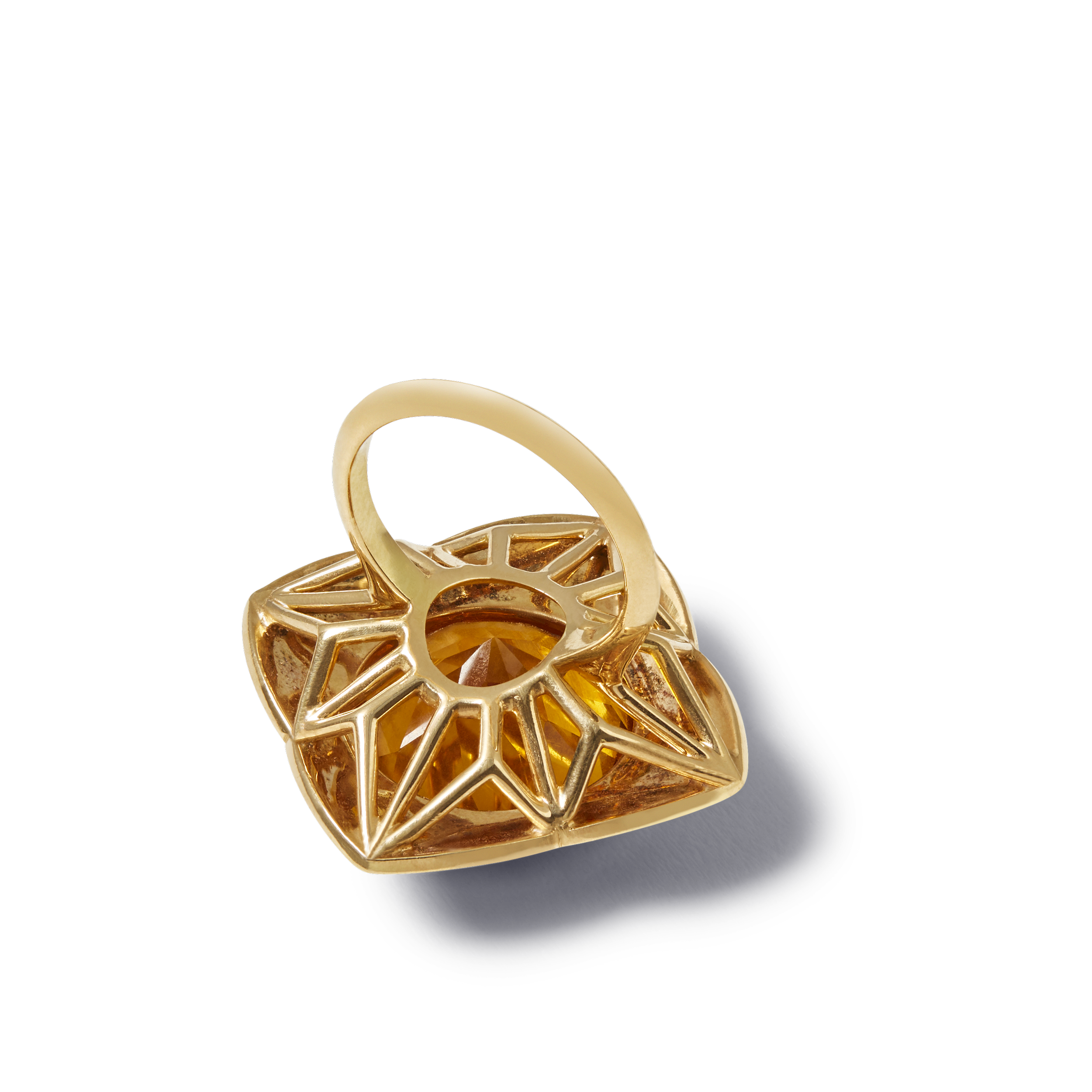 Gold ring with an intricate openwork design and a large amber gemstone. SUNRISE AURORA RING BY Tarra Rosenbaum. Gold ring with a large, faceted yellow citrine and vitreous enamel.