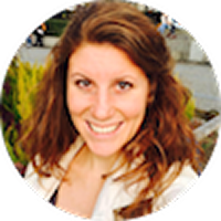 Time to Surf review profile image - A smiling person with shoulder-length curly brown hair.