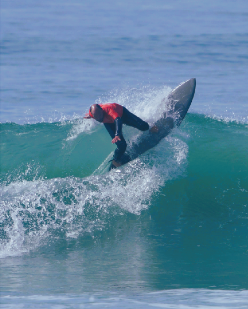 Person surfing on a wave in the ocean.