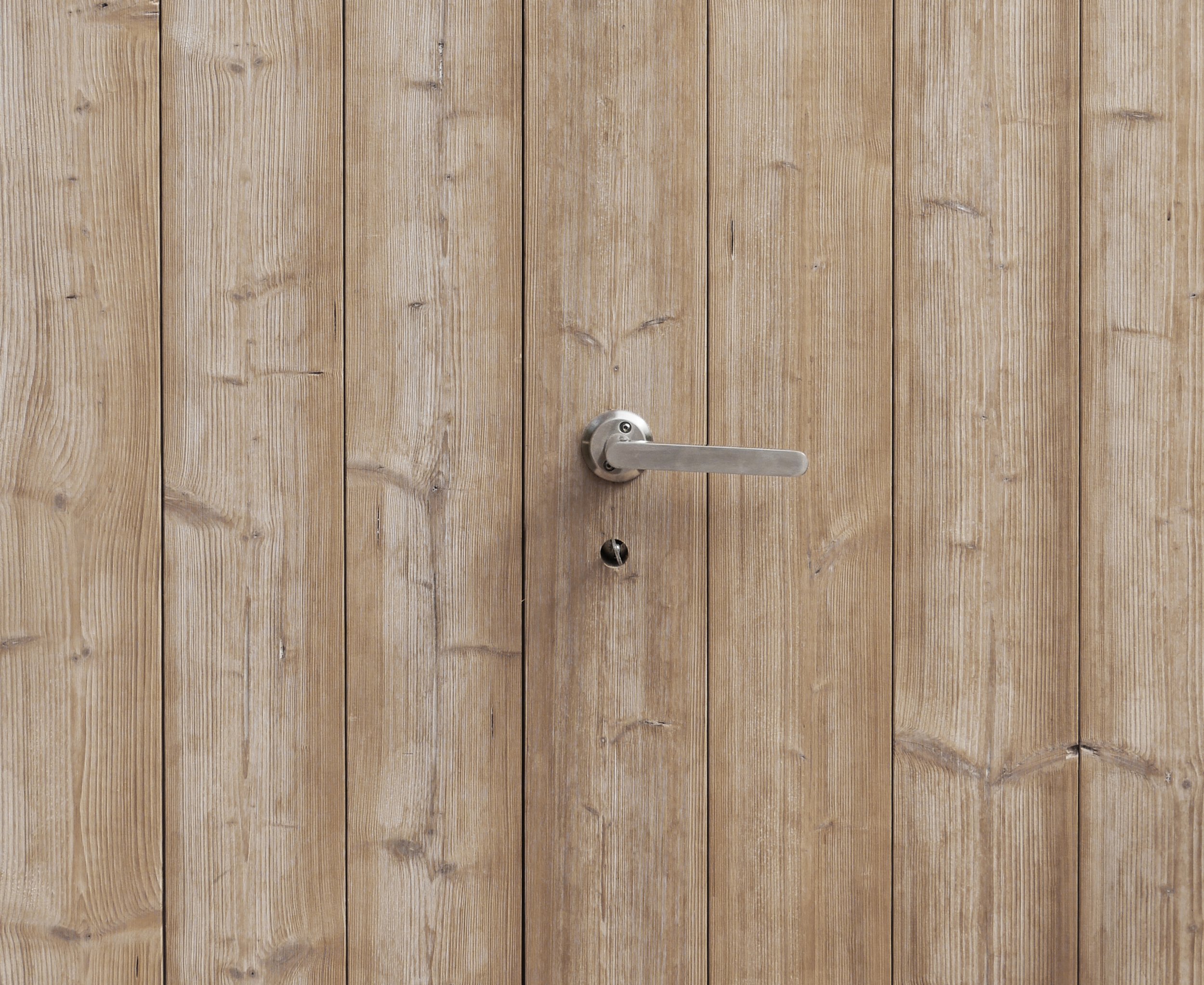 Wooden door with a silver door handle and a keyhole.