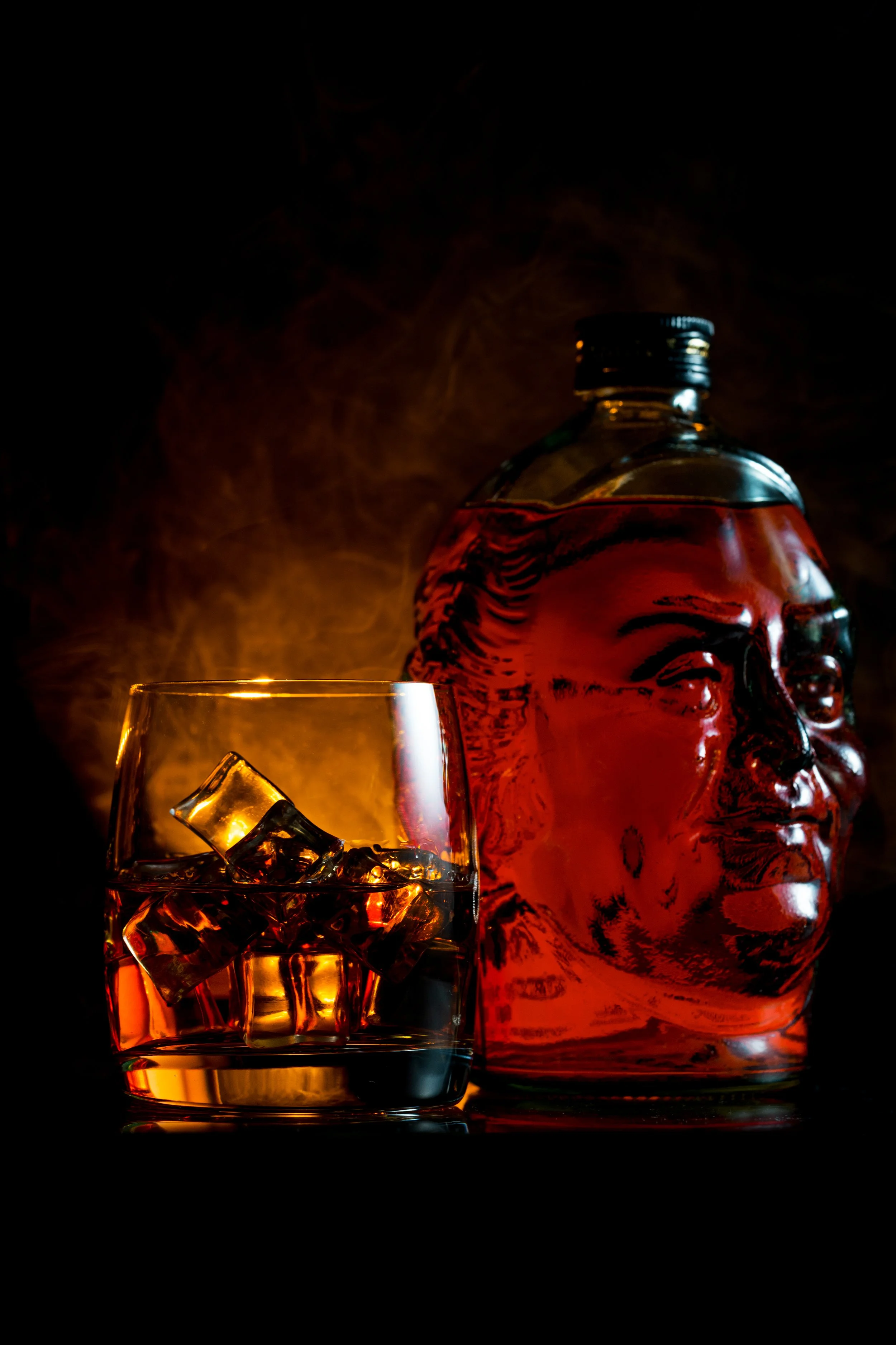 ark moody product photography of a whiskey bottle and glass with ice cubes, shot in dramatic low-key lighting
