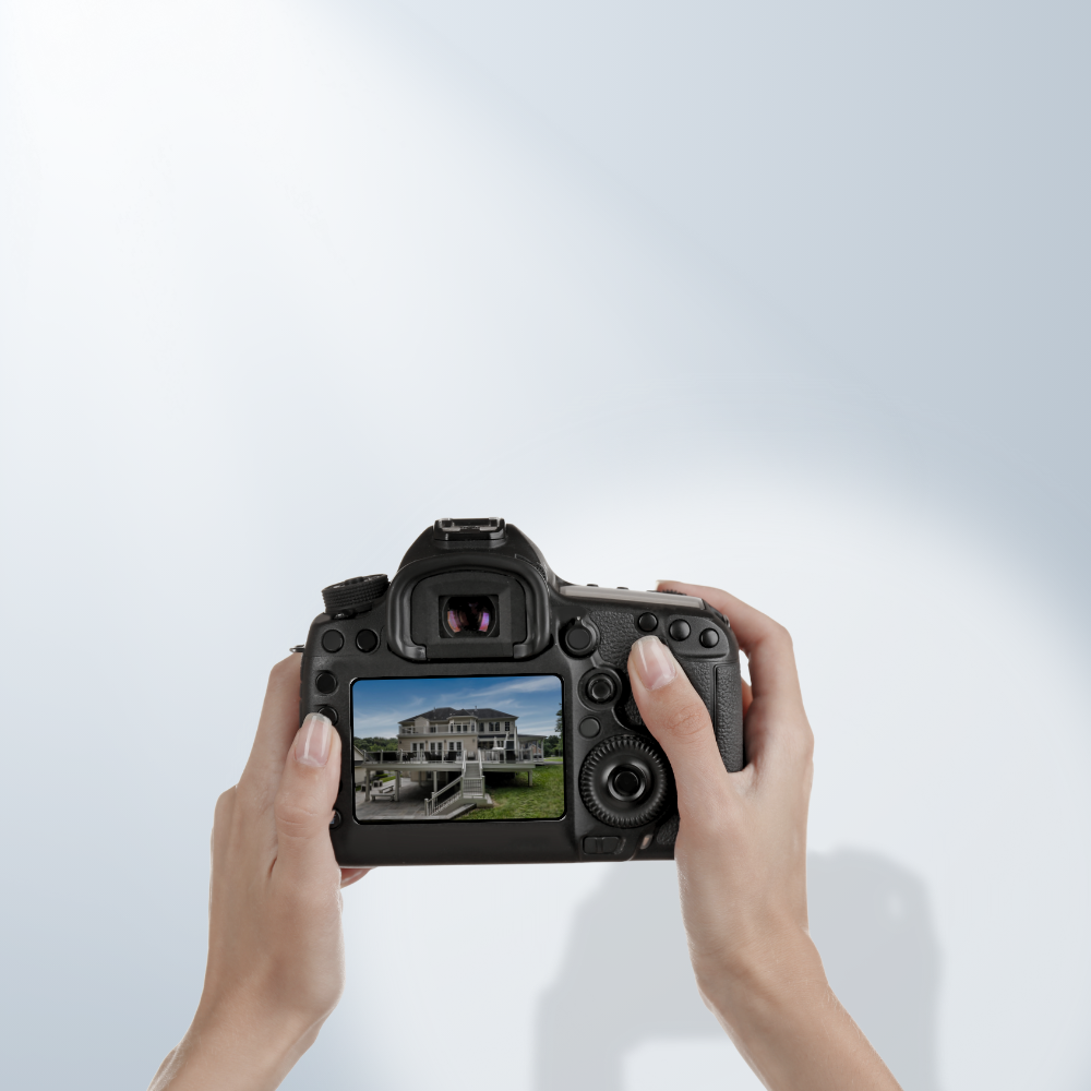Person holding a camera, capturing an image of a house with a porch and stairs.