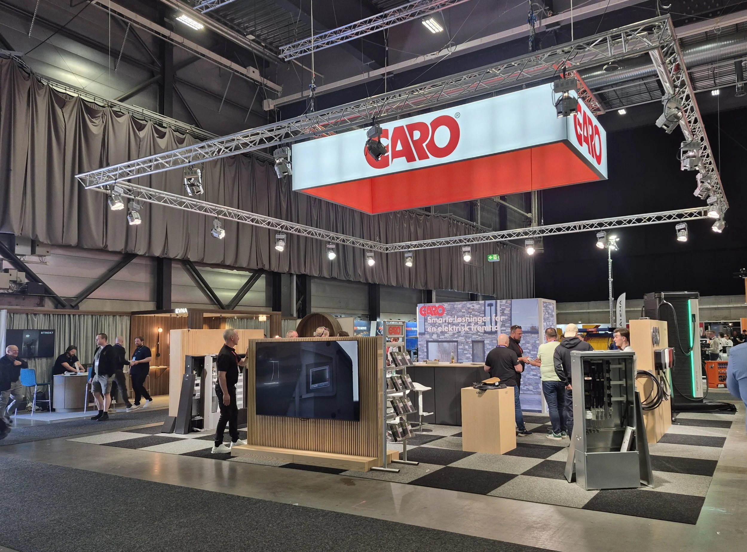 GARO messestand med stor hengende lysrigg, bakrom og produktutstilling