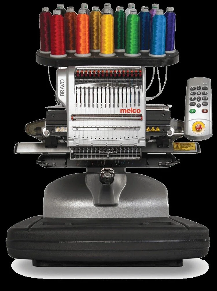 A computerized embroidery machine with spools of colorful thread on top, buttons and controls on a side panel, and a working area for embroidering designs.