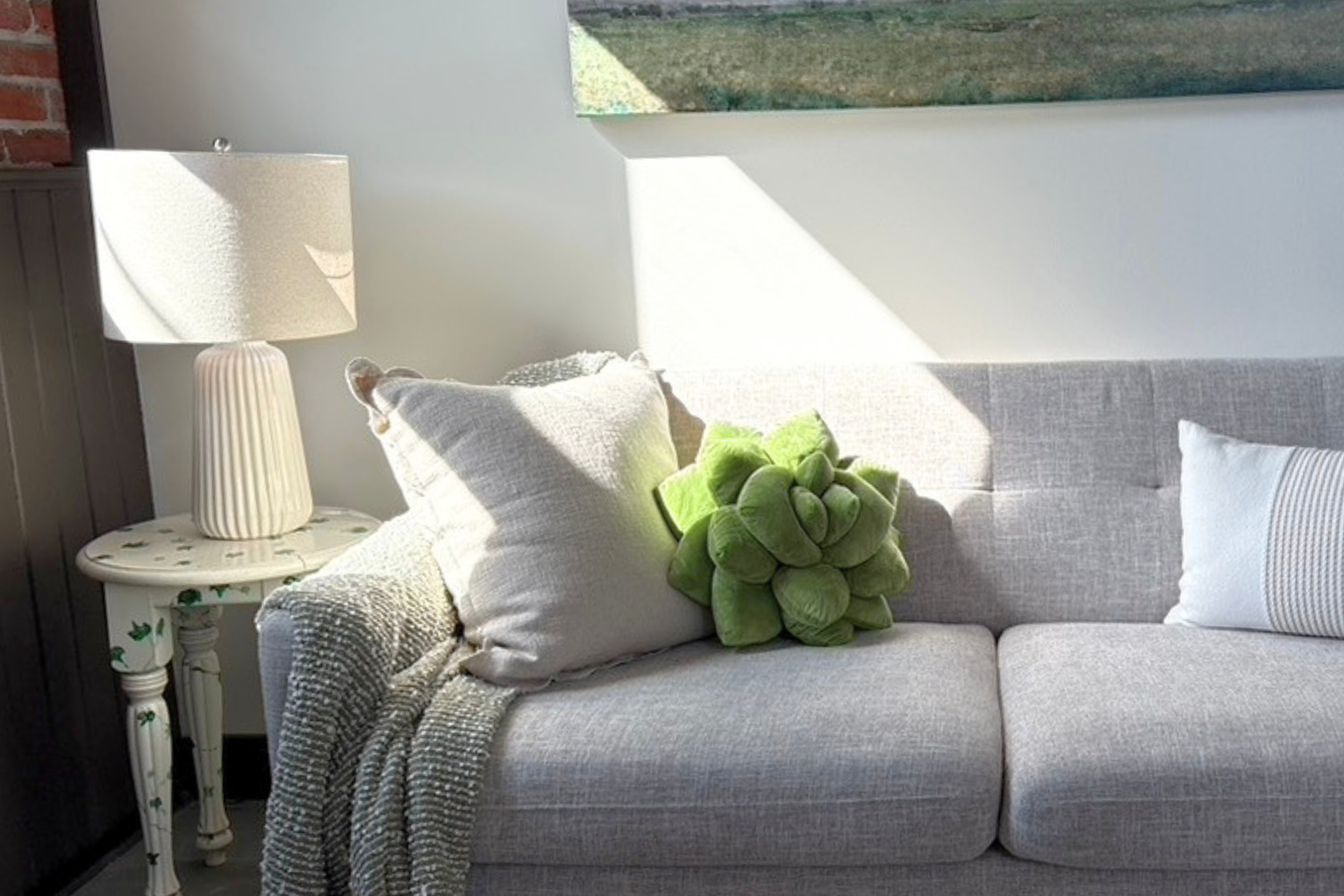 A therapist's couch with pillows and a blanket and sunlight gently streaming into the room