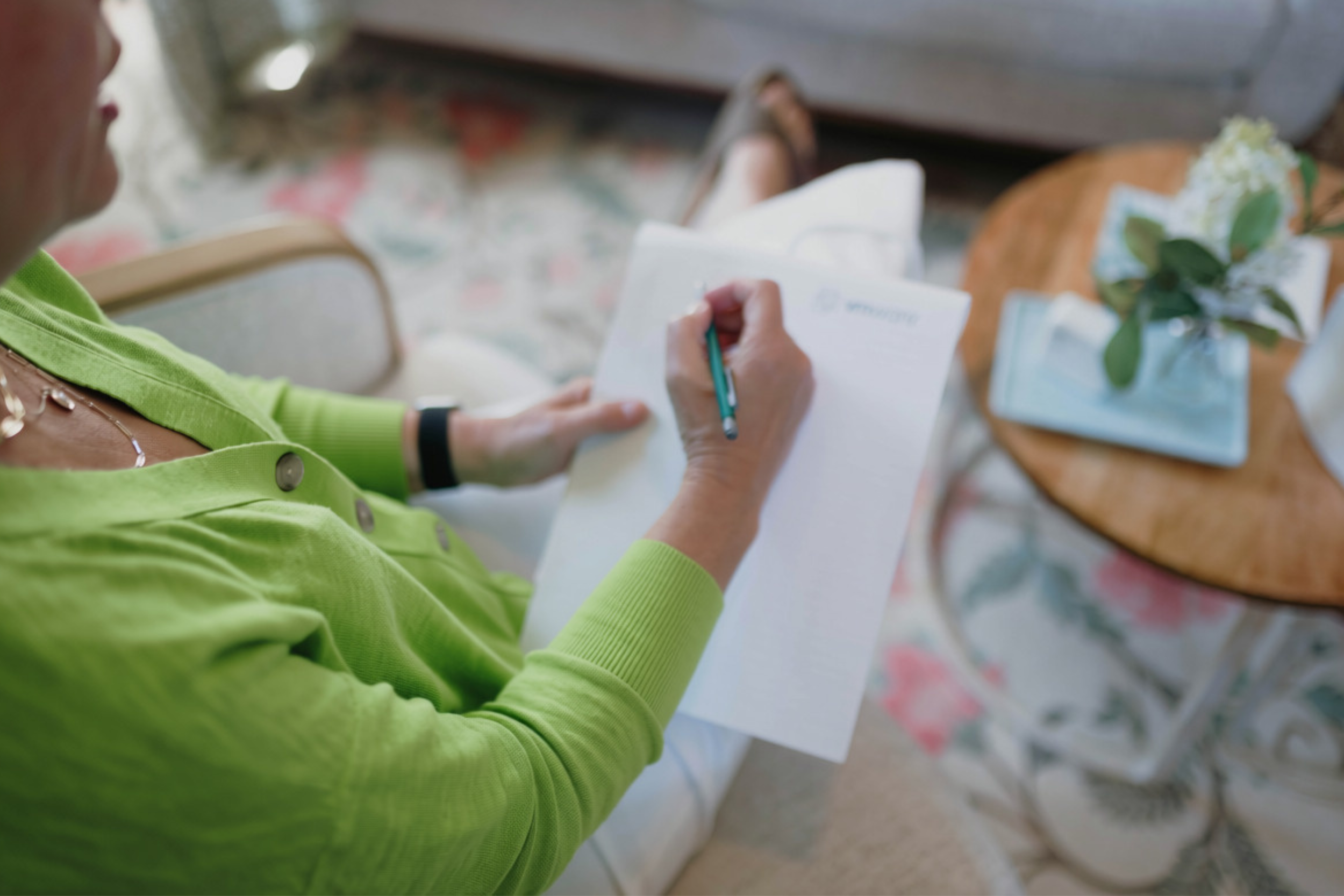 Grieving woman writing in notebook getting things done.